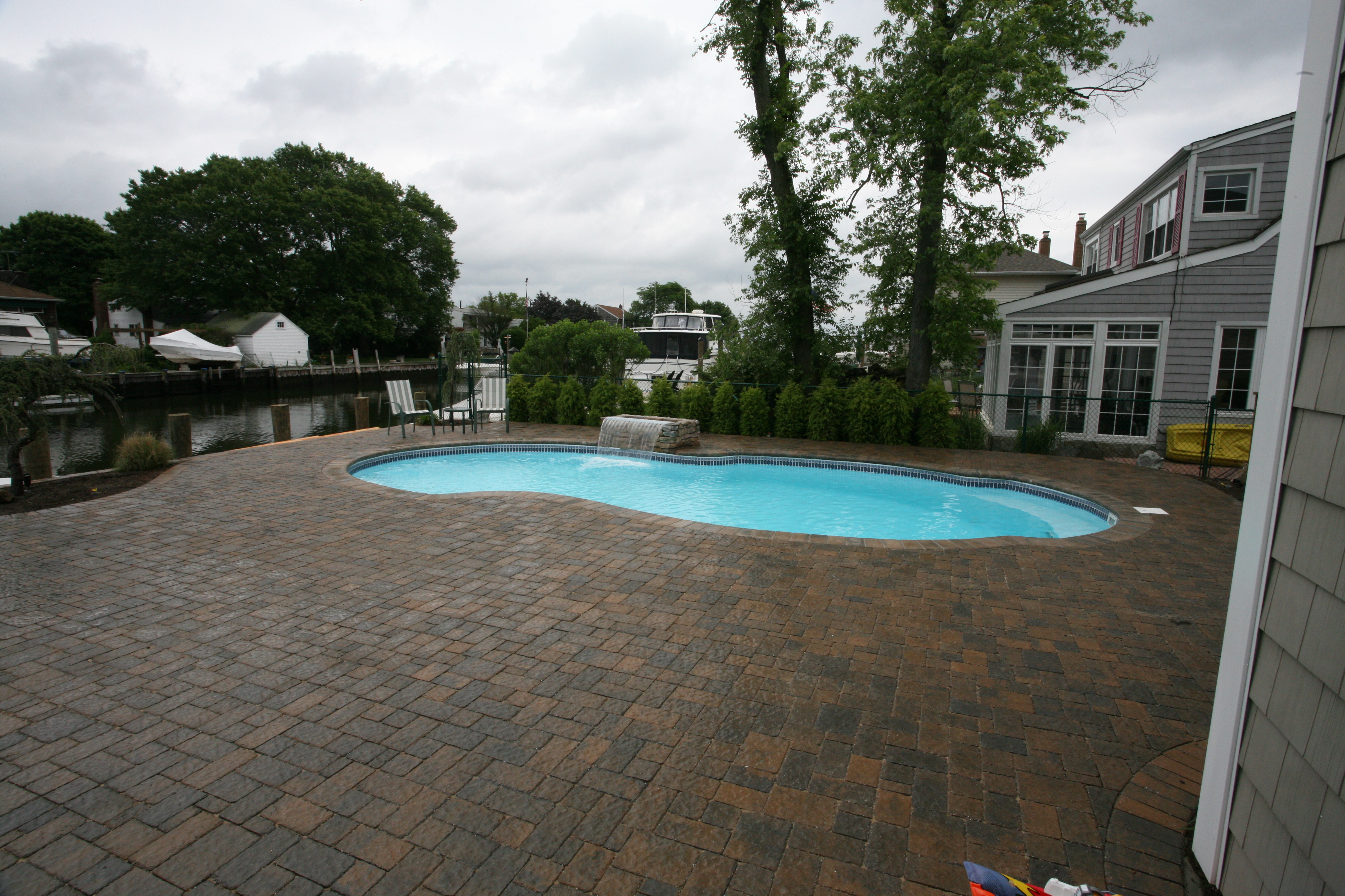 Enjoy the serenity of this beautifully finished fiberglass pool, surrounded by lush greenery and a tranquil waterfall, perfect for peaceful relaxation.
