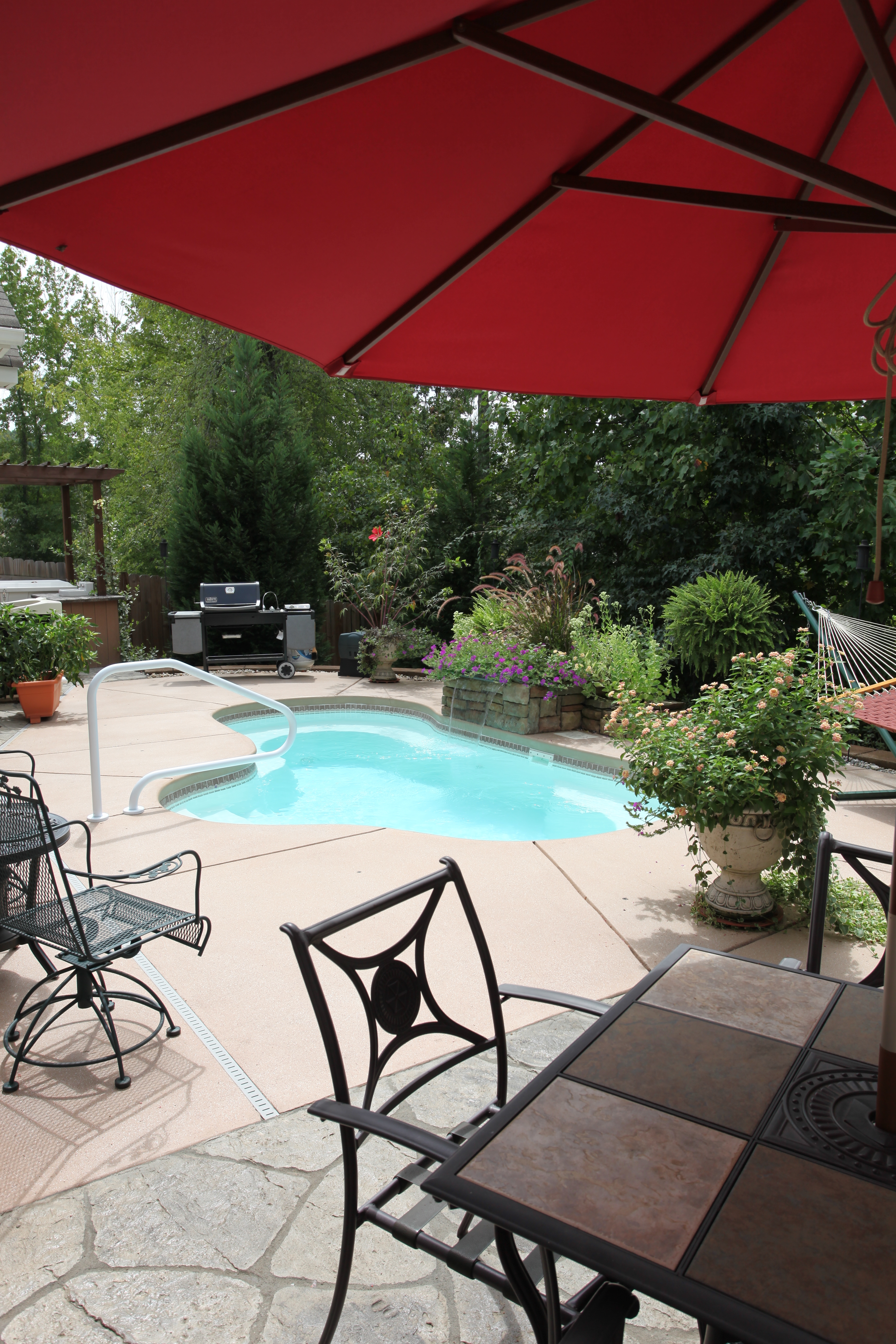 Experience the serene luxury of a custom fiberglass in-ground pool, nestled in a sunlit backyard oasis designed for relaxation and entertaining.