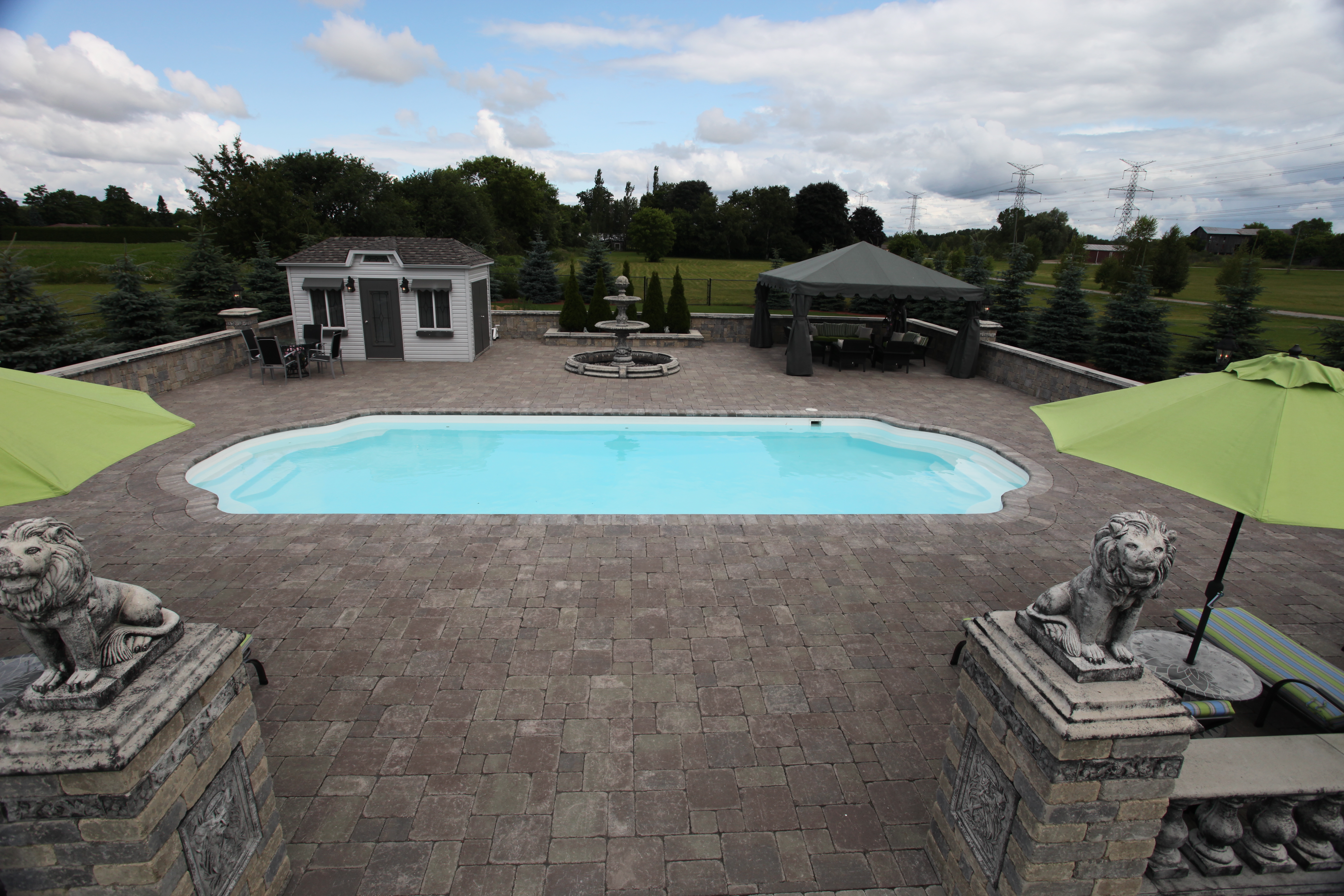 Enjoy serene luxury in this beautifully installed fiberglass pool, surrounded by a manicured lawn and stone patio.