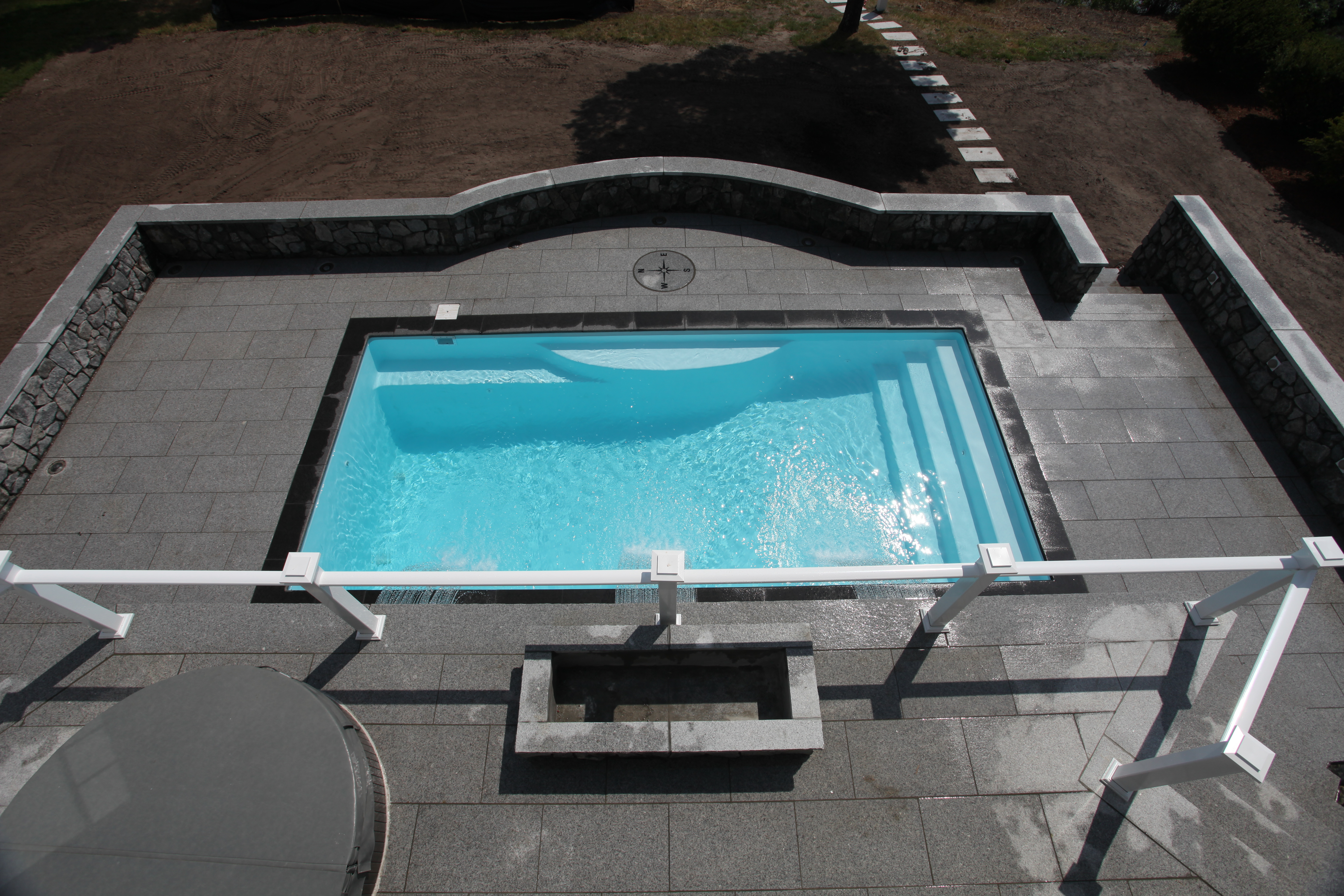 Enjoy a tranquil, light-blue fiberglass pool in a serene backyard setting—perfect for summer relaxation.