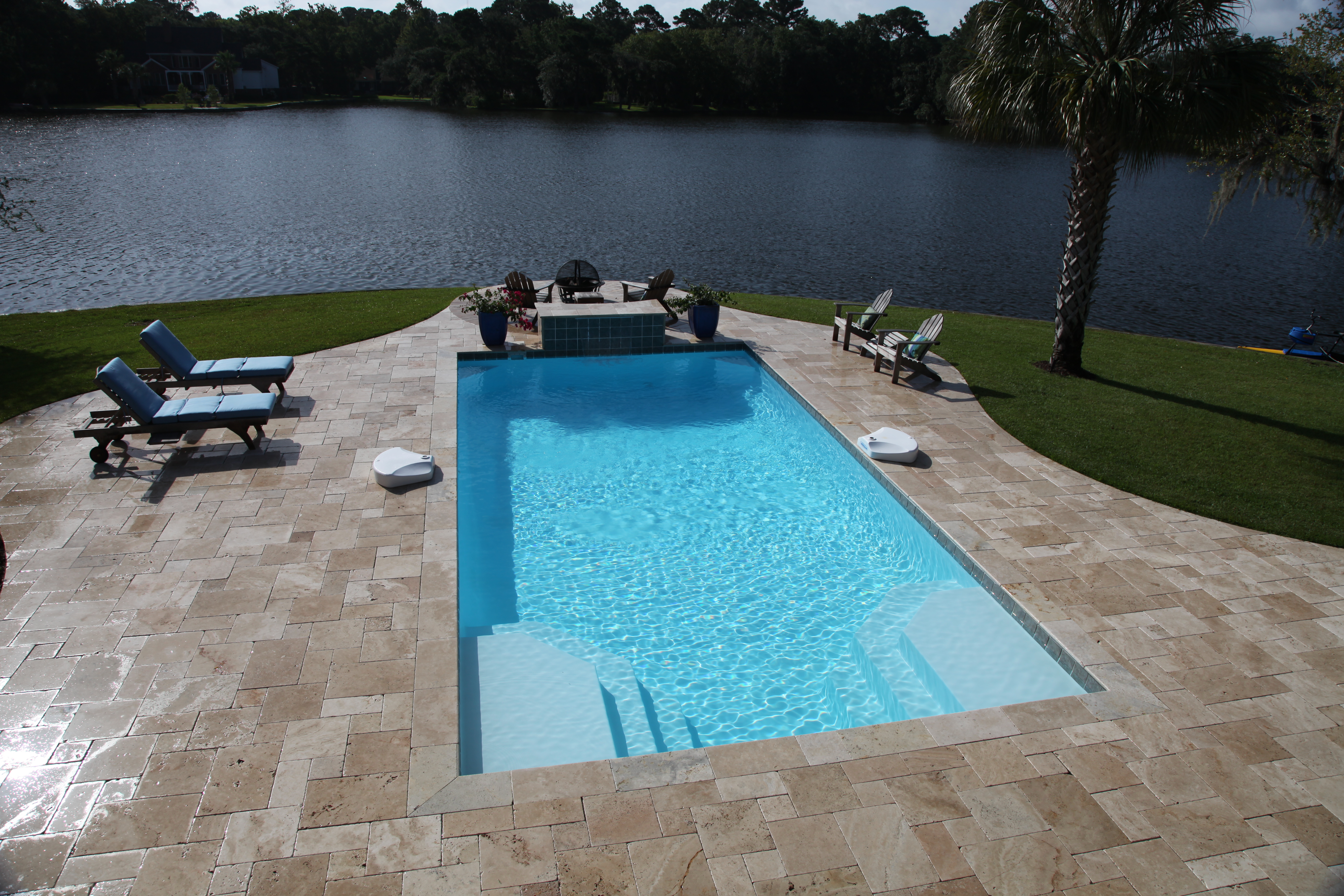 Enjoy the serene, crystal-clear water of our new fiberglass pool, surrounded by a spacious stone deck and lush greenery for the ultimate backyard escape.
