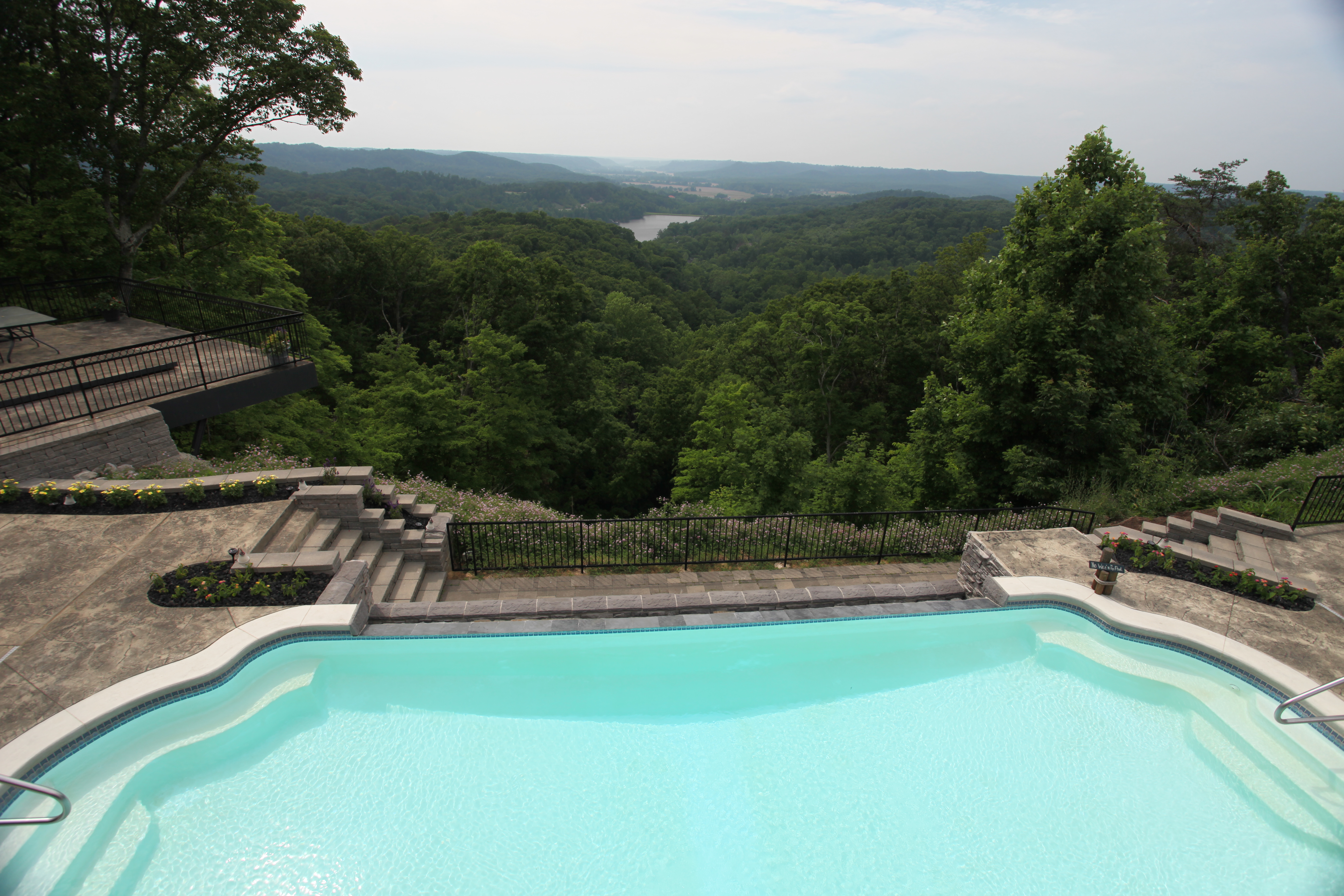 Experience tranquil luxury with this stunning free-form fiberglass pool, set amid a natural stone patio and vibrant garden.