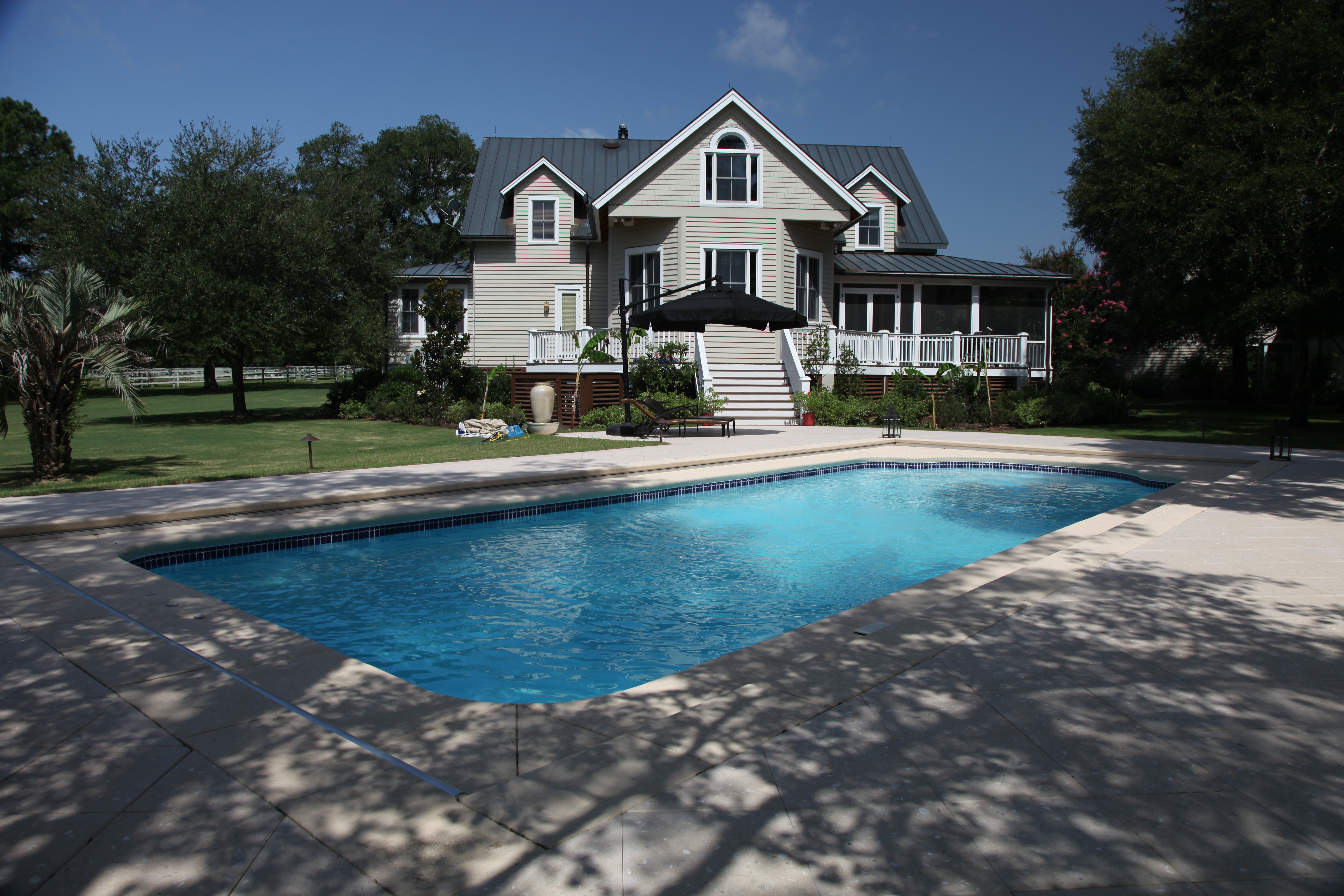 Enjoy a crystal-clear, fiberglass pool set in a sun-kissed backyard oasis, perfect for relaxed summer days.