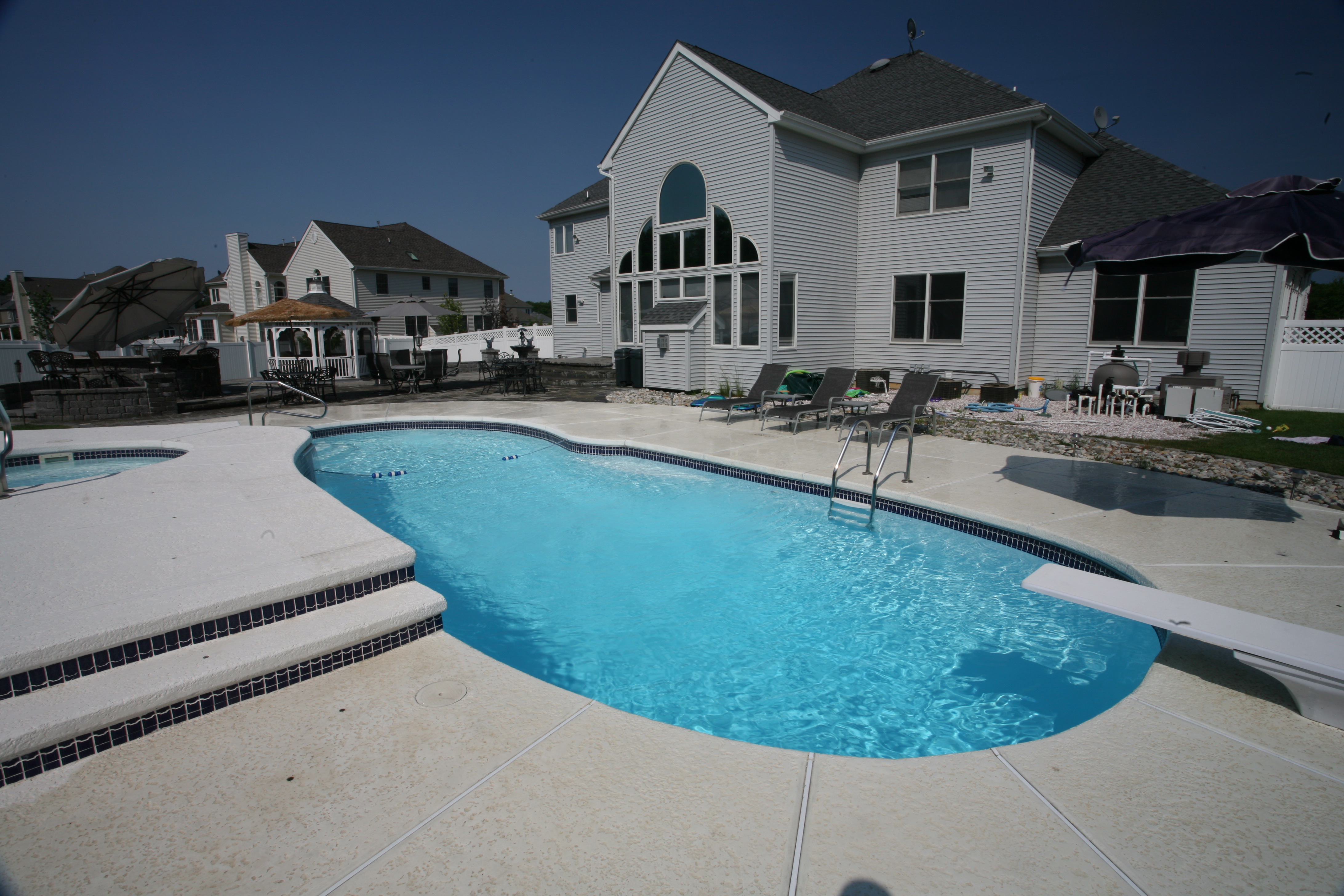 Experience the crystal-clear luxury of a San Juan fiberglass pool, perfectly installed in a sun-kissed suburban backyard.