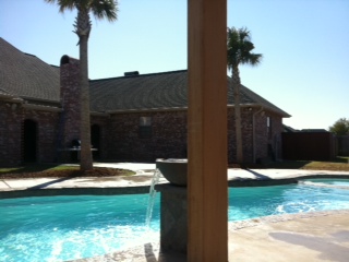 Enjoy sunny relaxation in this luxurious fiberglass pool, set in a bright backyard oasis.