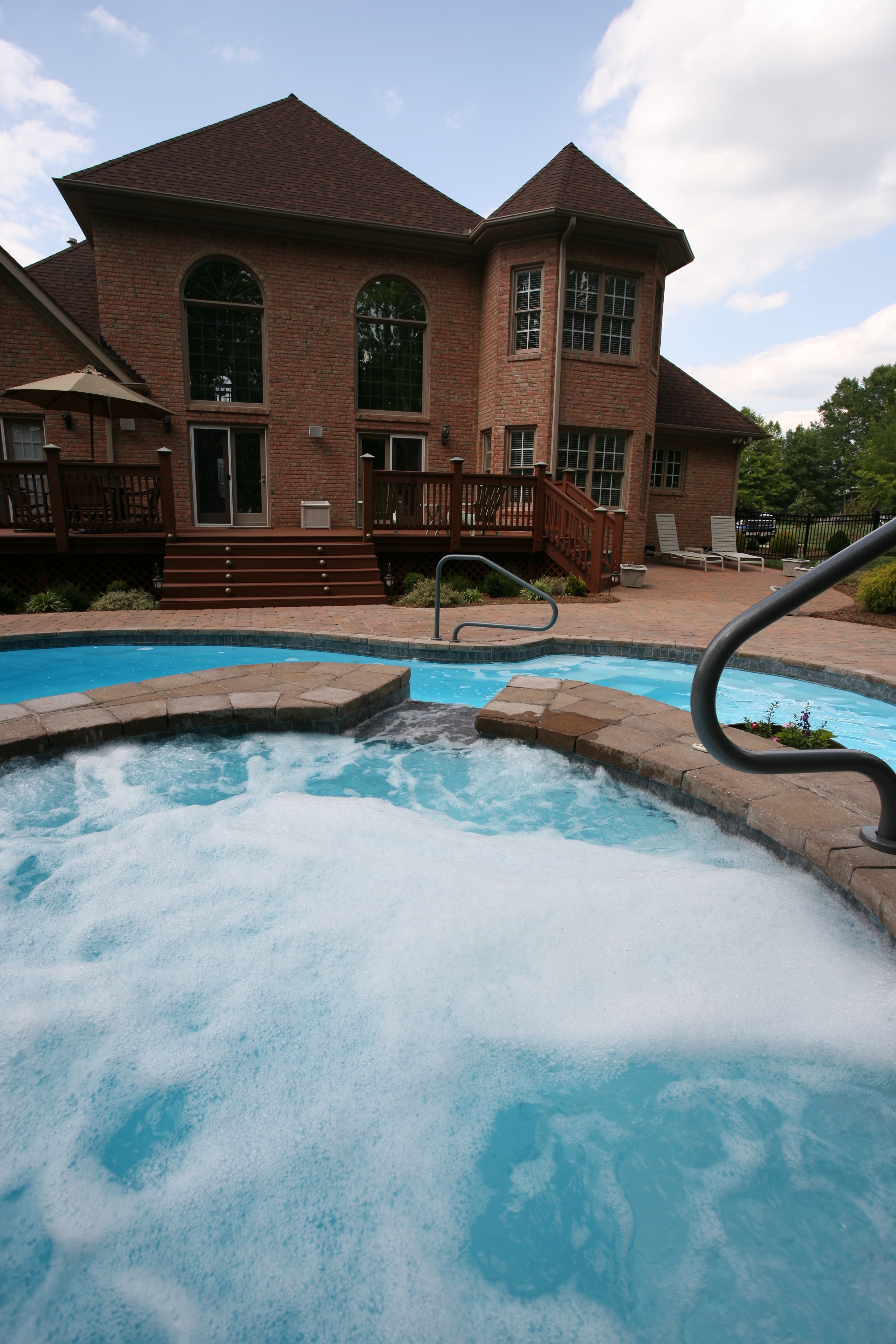 Experience the serene luxury of a San Juan fiberglass pool and hot tub nestled in a sun-lit backyard oasis.