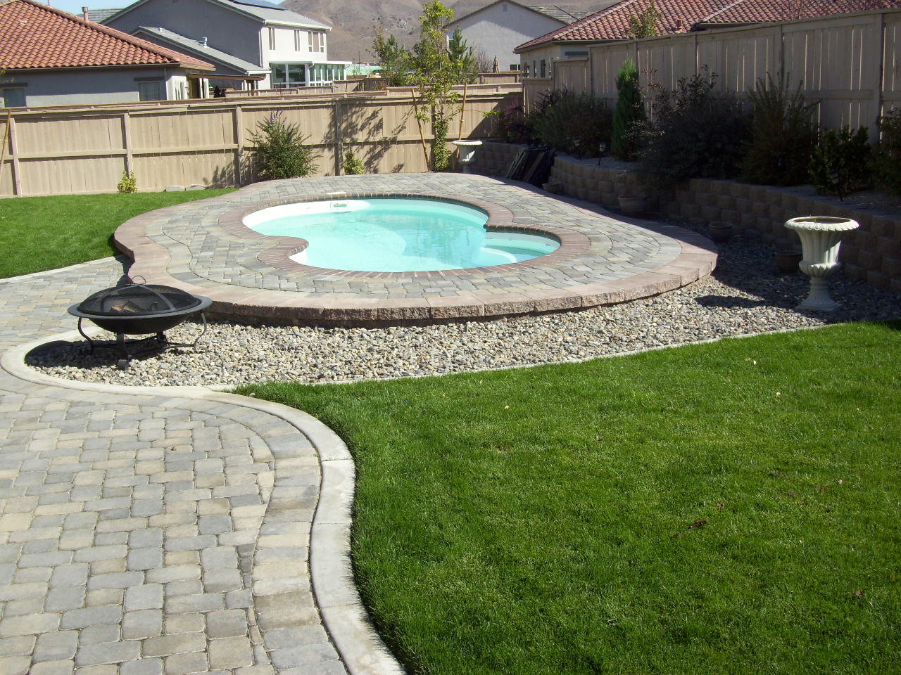 Enjoy crystal-clear turquoise waters in this inground fiberglass pool, nestled within a meticulously landscaped backyard oasis.
