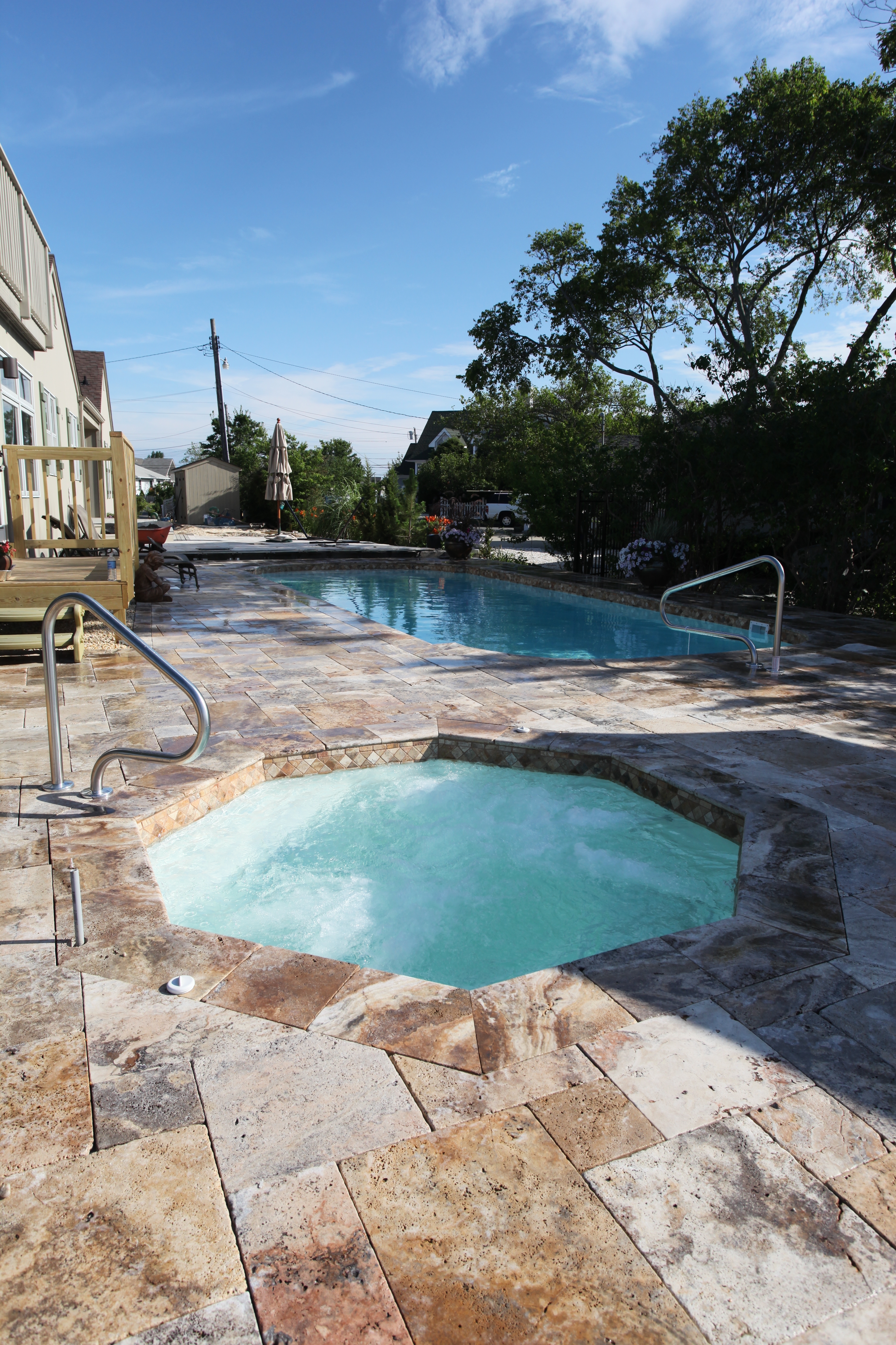 A serene inground pool in a lush backyard, perfect for summer relaxation in the Southeast's humid climate. The modern aesthetic and warm tones evoke a sense of calm and tranquility.