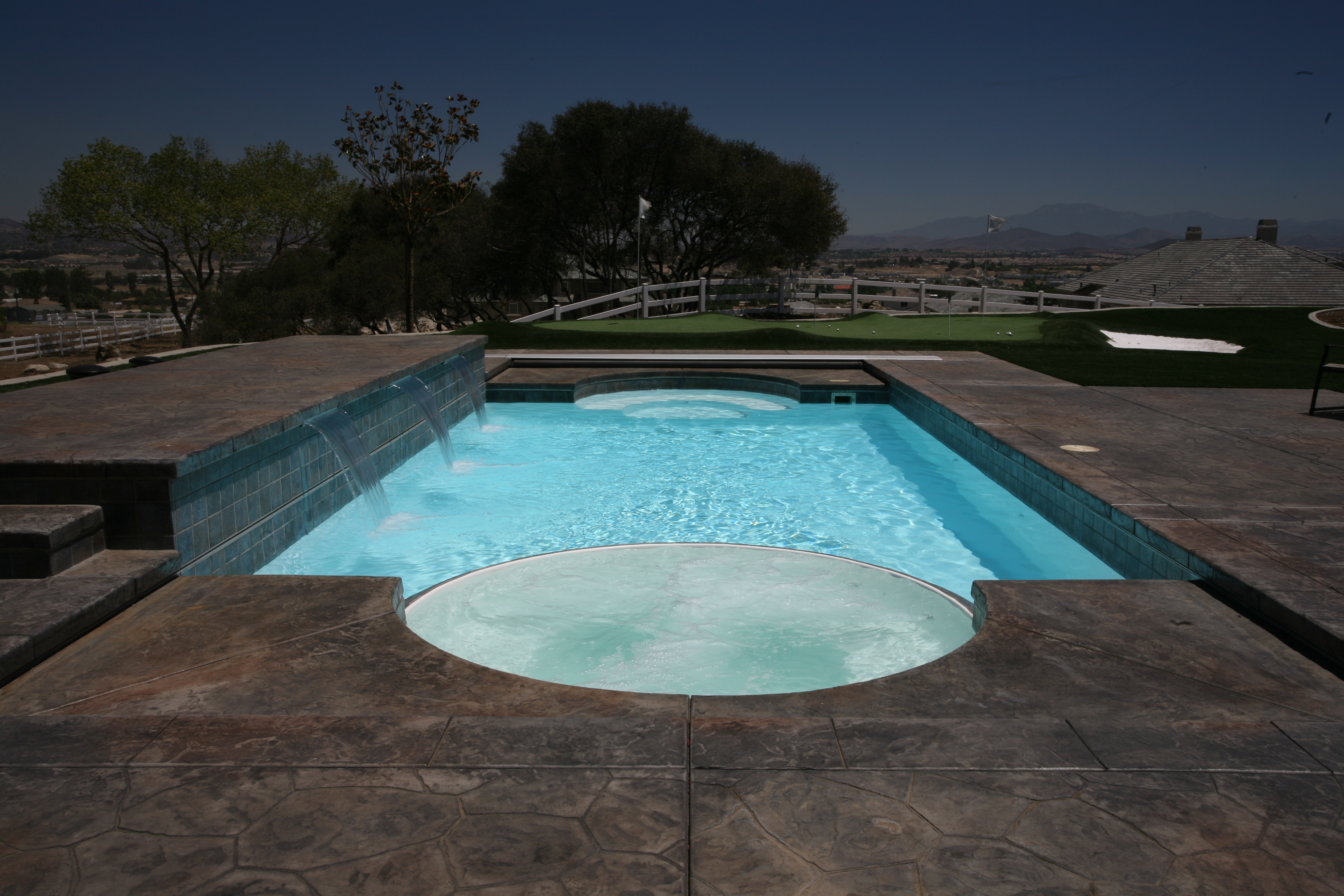 Escape to tranquility with this fiberglass pool, nestled in a lush backyard oasis with a stunning mountain backdrop.