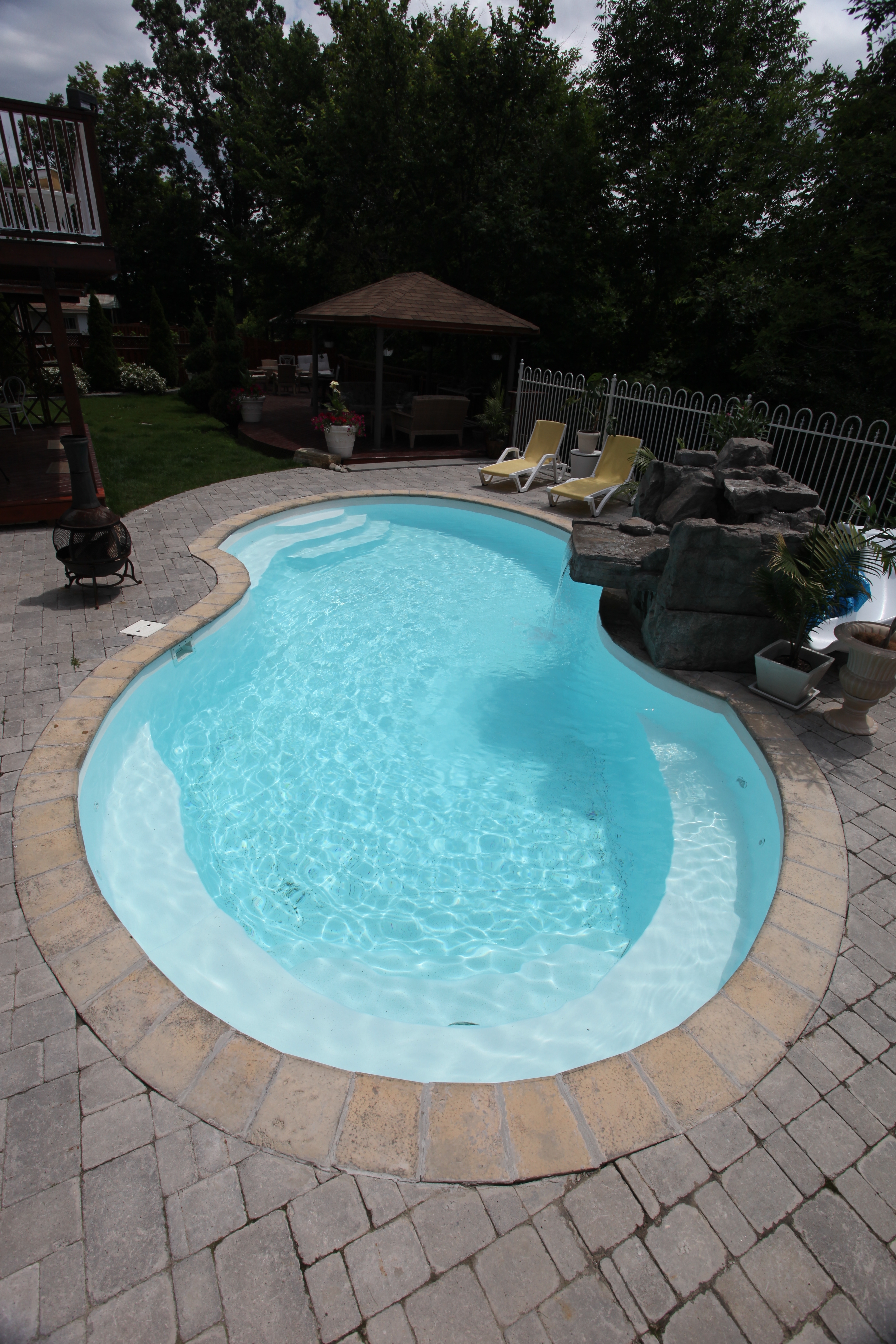 A serene inground pool in a modern backyard setting, perfect for relaxation in the desert climate. The pool's clean lines and minimalist aesthetic create a sense of calm, inviting you to unwind and enjoy the warm summer sun.