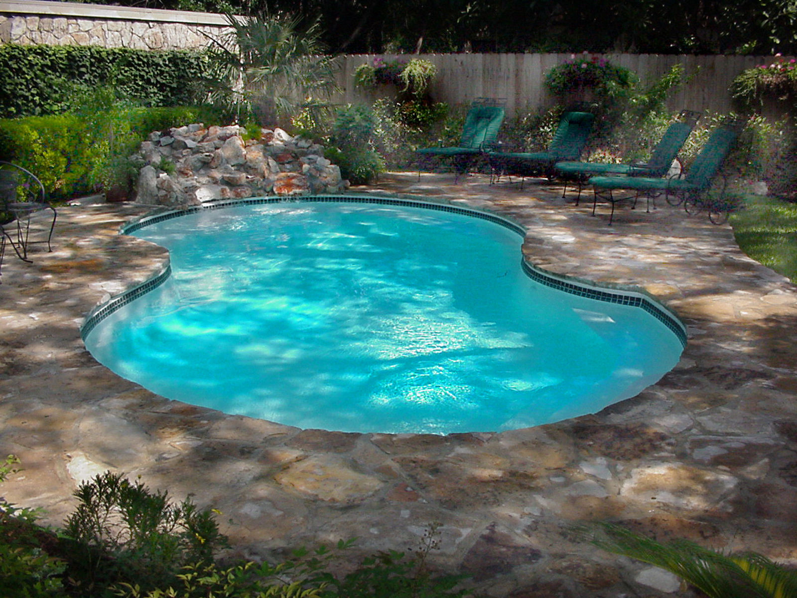 A serene inground pool in a desert backyard, perfect for a relaxing summer day. The classic design blends seamlessly into the surrounding landscape.