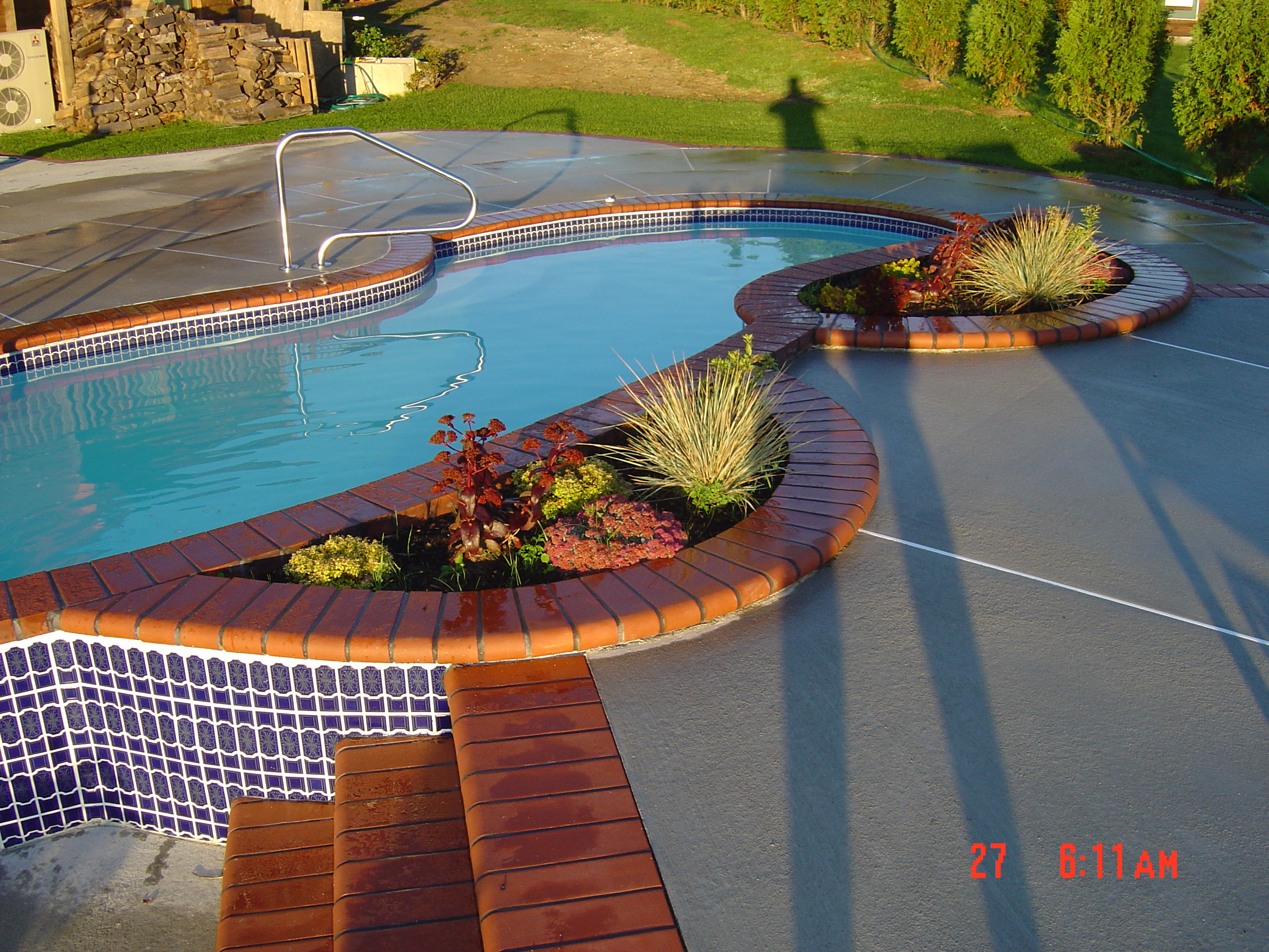 Enjoy a tranquil backyard oasis with a gleaming fiberglass pool bathed in warm late-afternoon light.