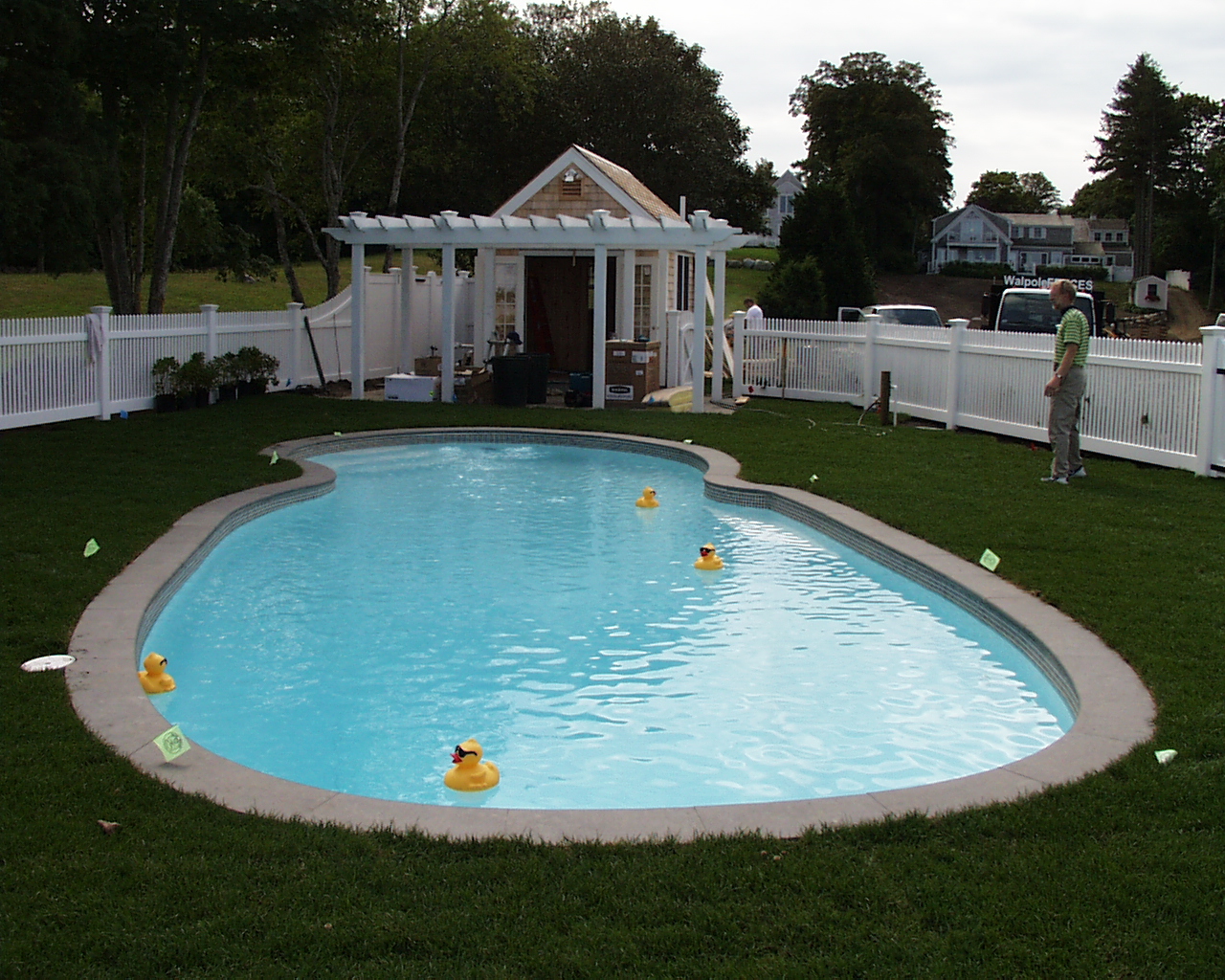Enjoy endless summer fun in this pristine fiberglass kidney-shaped pool, the centerpiece of a beautifully landscaped backyard.