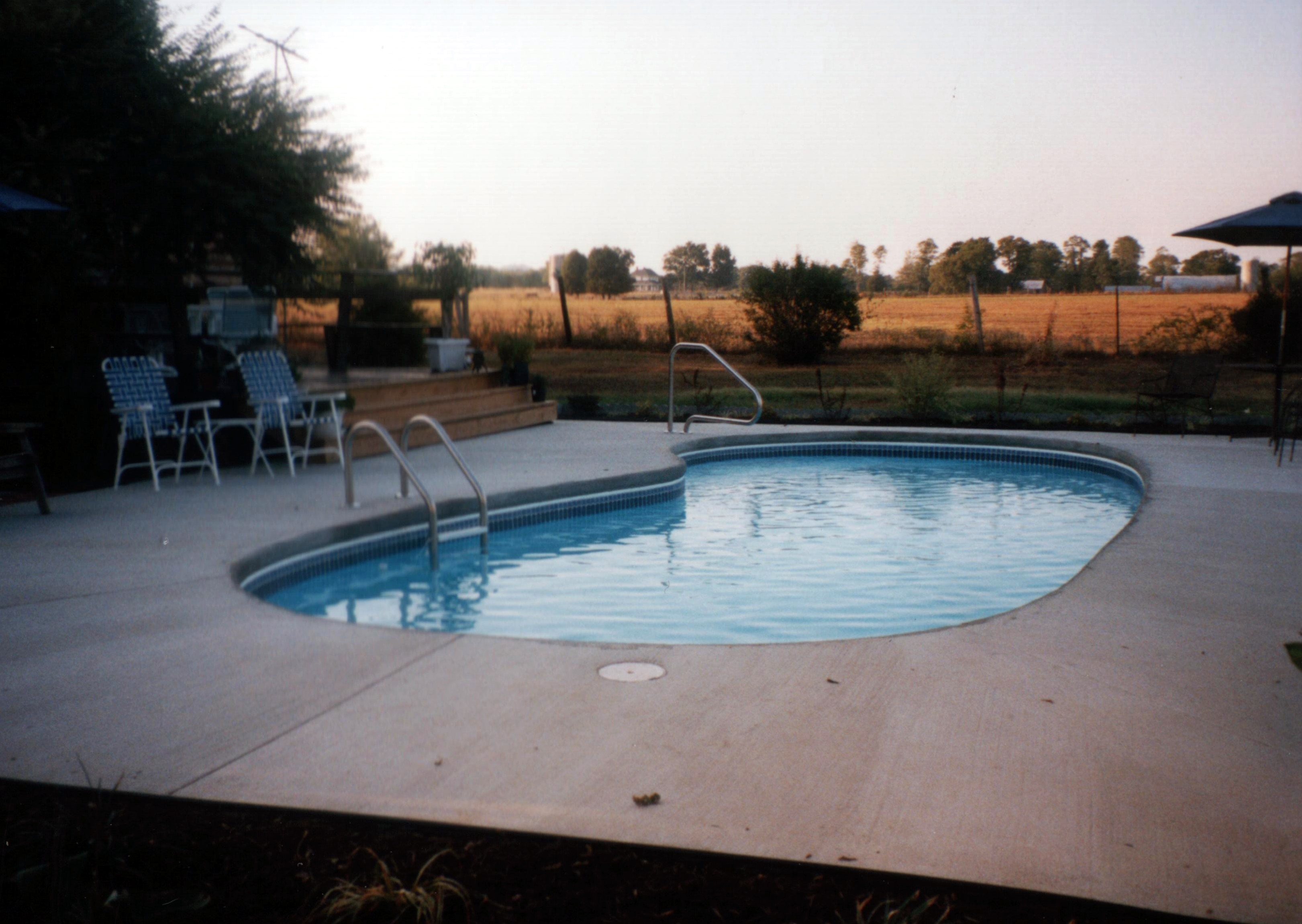 A serene inground pool in a desert backyard, perfect for relaxation on a warm summer day. The modern design and clean lines create a tranquil oasis.
