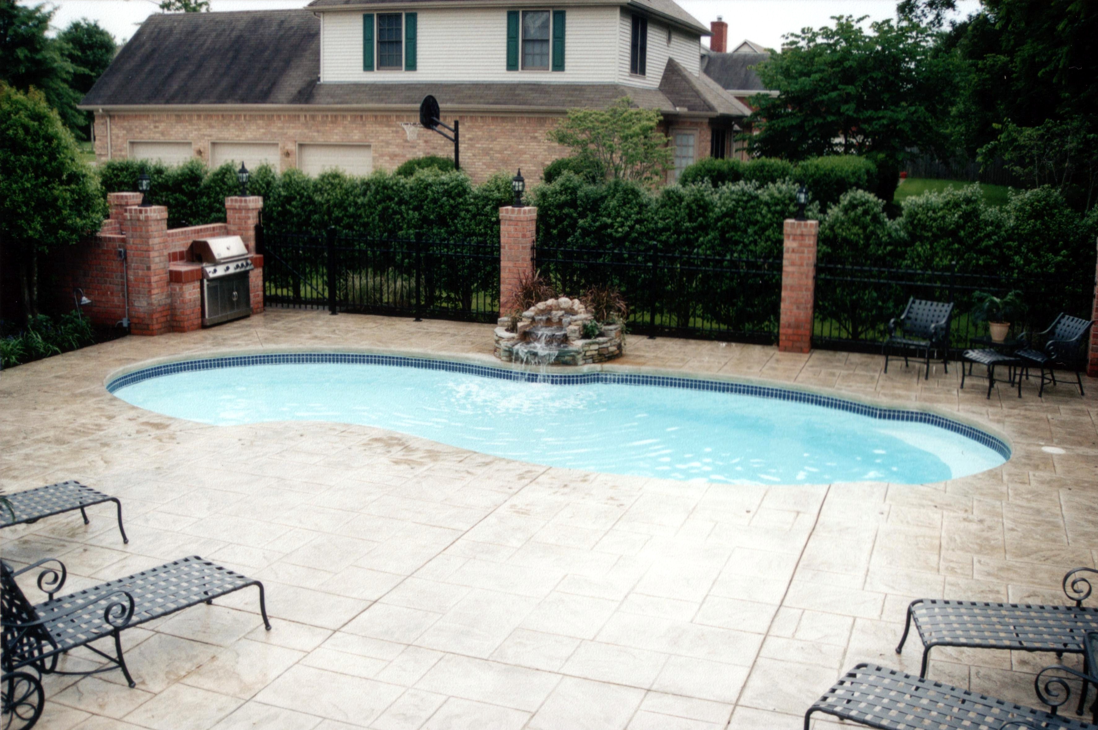 A serene inground pool in a desert backyard, perfect for hot summer days. The surrounding landscape adds to the relaxing ambiance, creating an ideal spot for leisure and entertainment.
