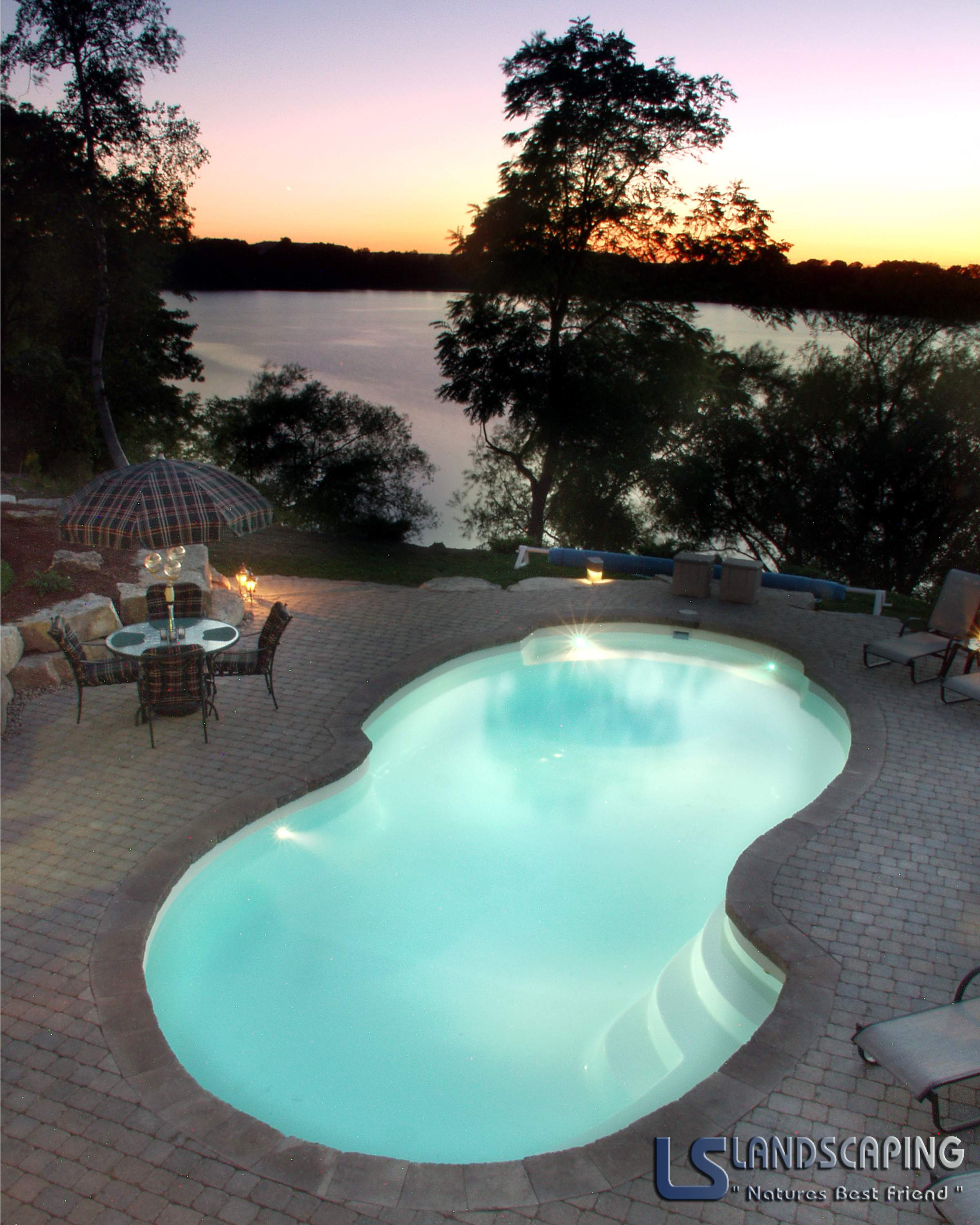 Experience serene evenings with this inviting kidney-shaped San Juan fiberglass pool, perfectly integrated into a lush backyard oasis.