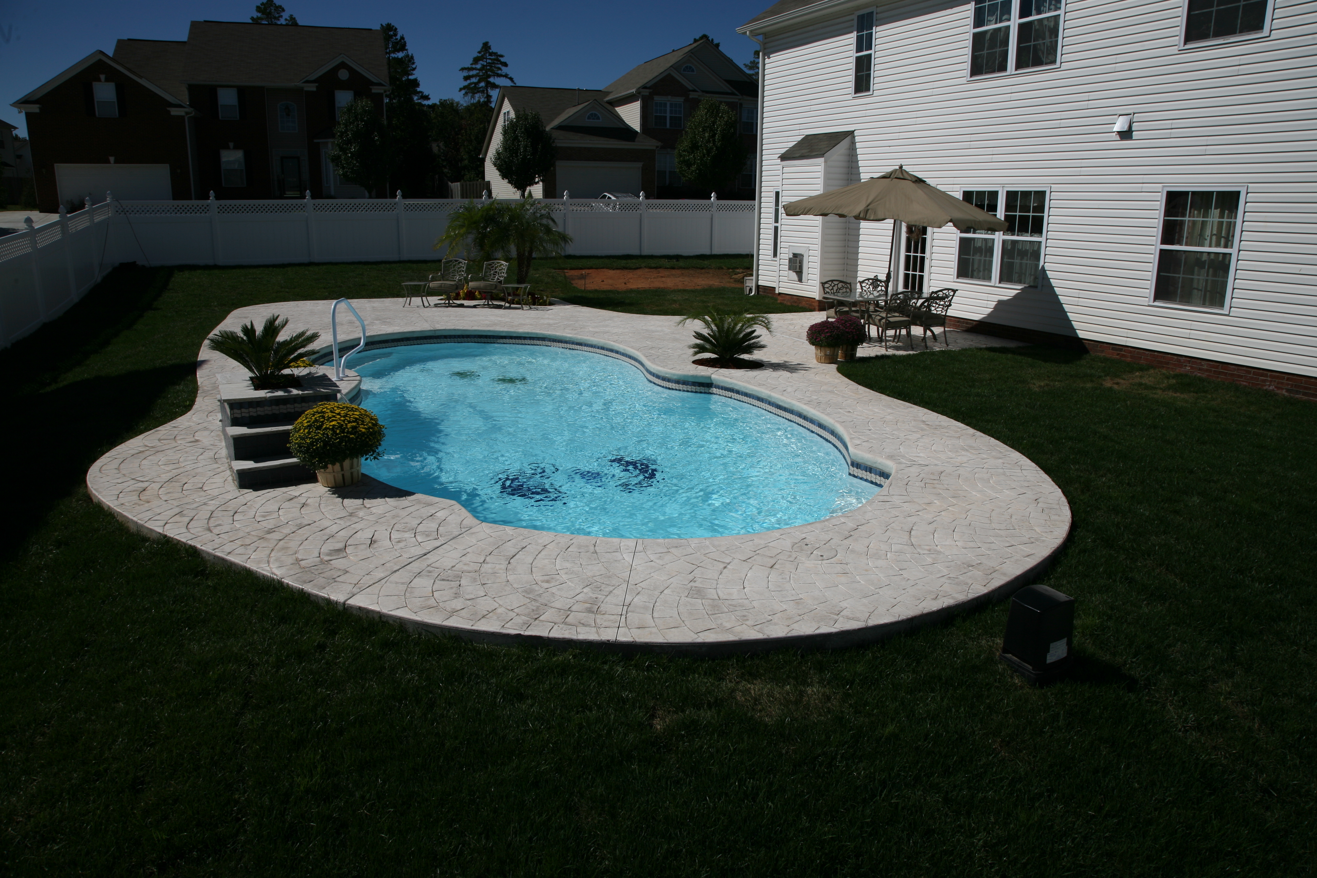 Escape to relaxation with this serene fiberglass pool nestled in a beautifully manicured backyard.