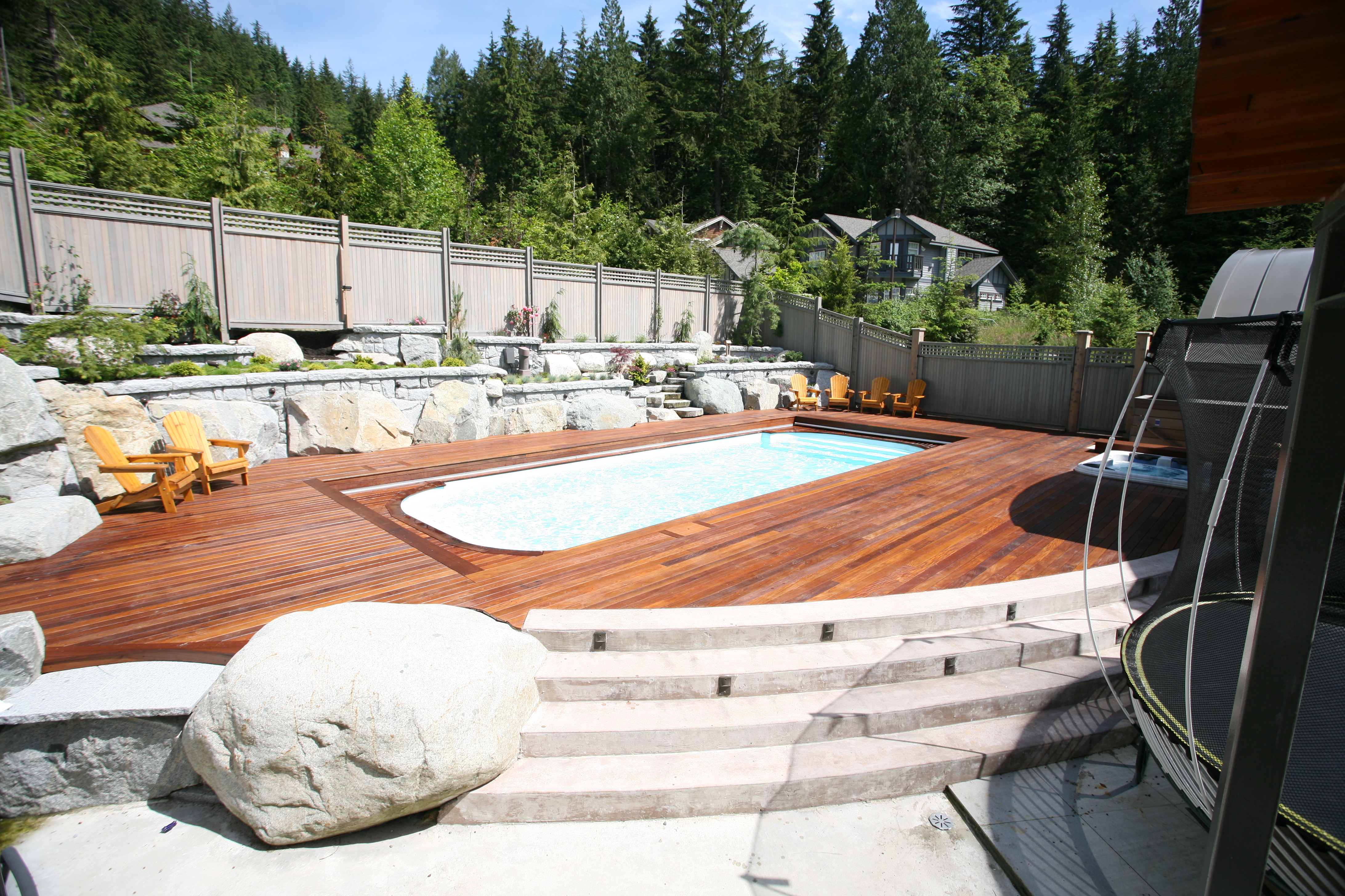 Relax and unwind in this serene backyard fiberglass pool, surrounded by lush greenery and natural beauty.