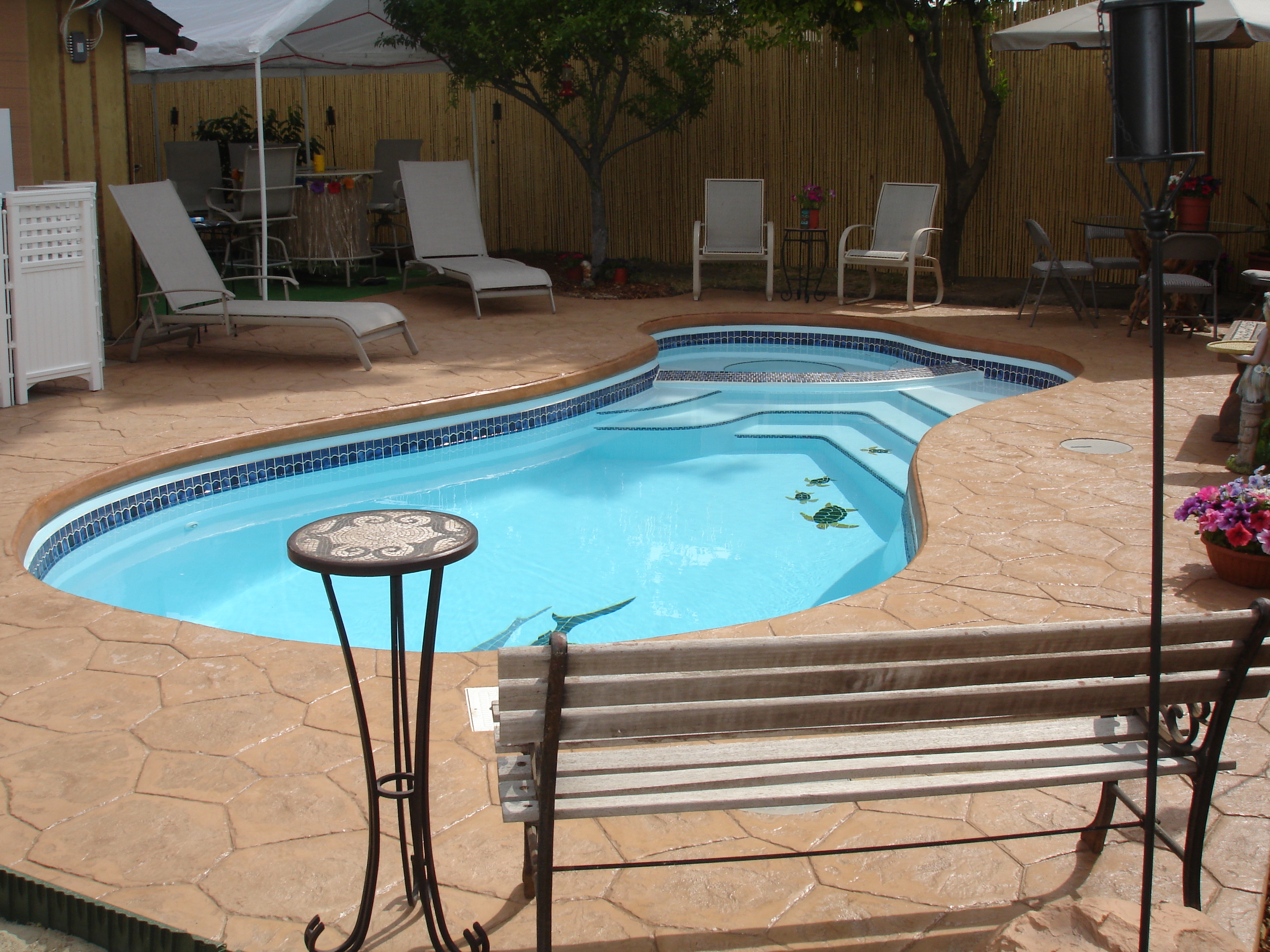 A serene desert backyard with a newly installed inground pool, perfect for hot summer days. The warm, natural tones of the setting create a relaxing atmosphere, ideal for a classic outdoor oasis.