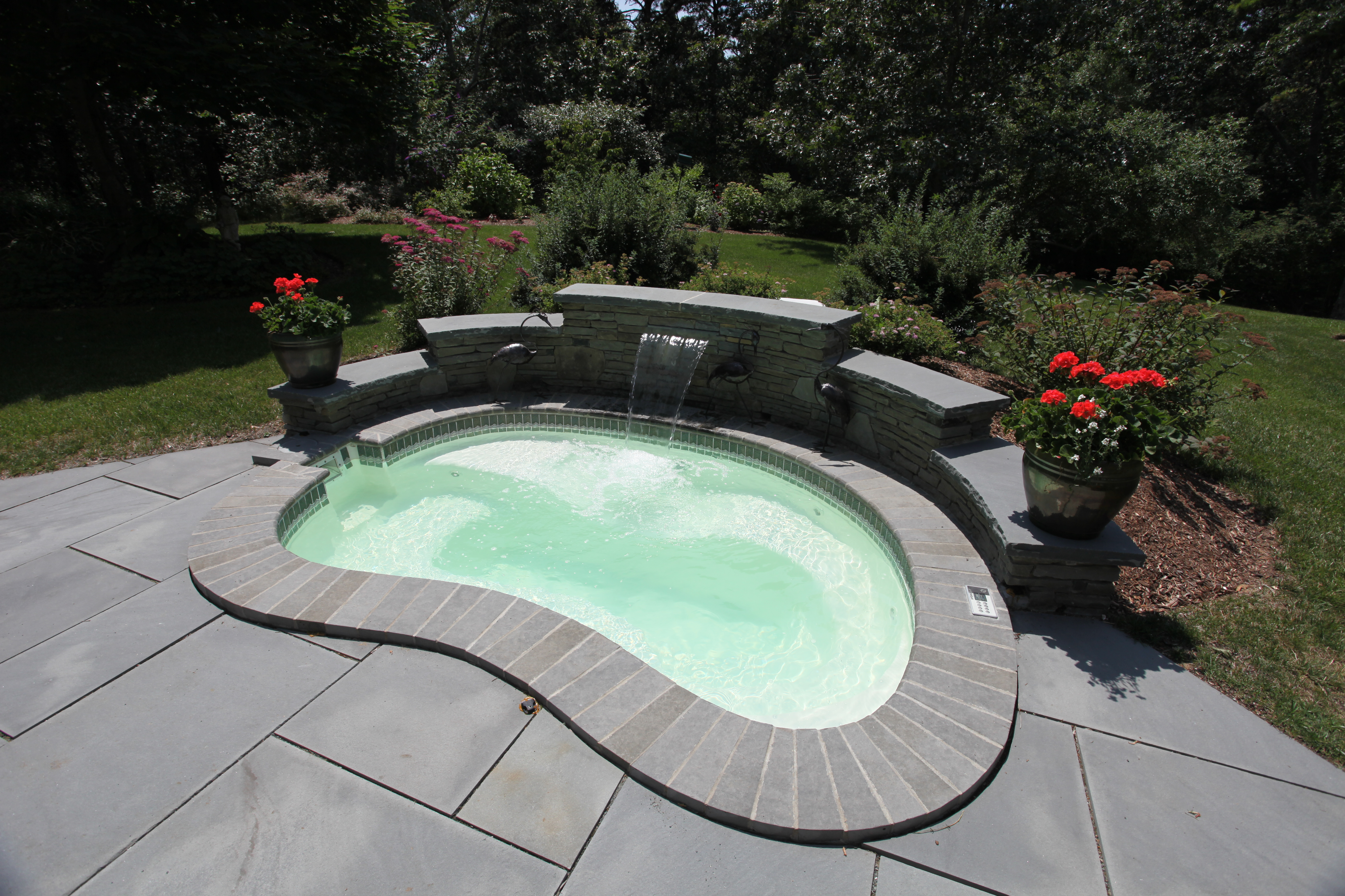 Immerse yourself in the serene beauty of this unique, fiberglass pool nestled in a lush backyard oasis.