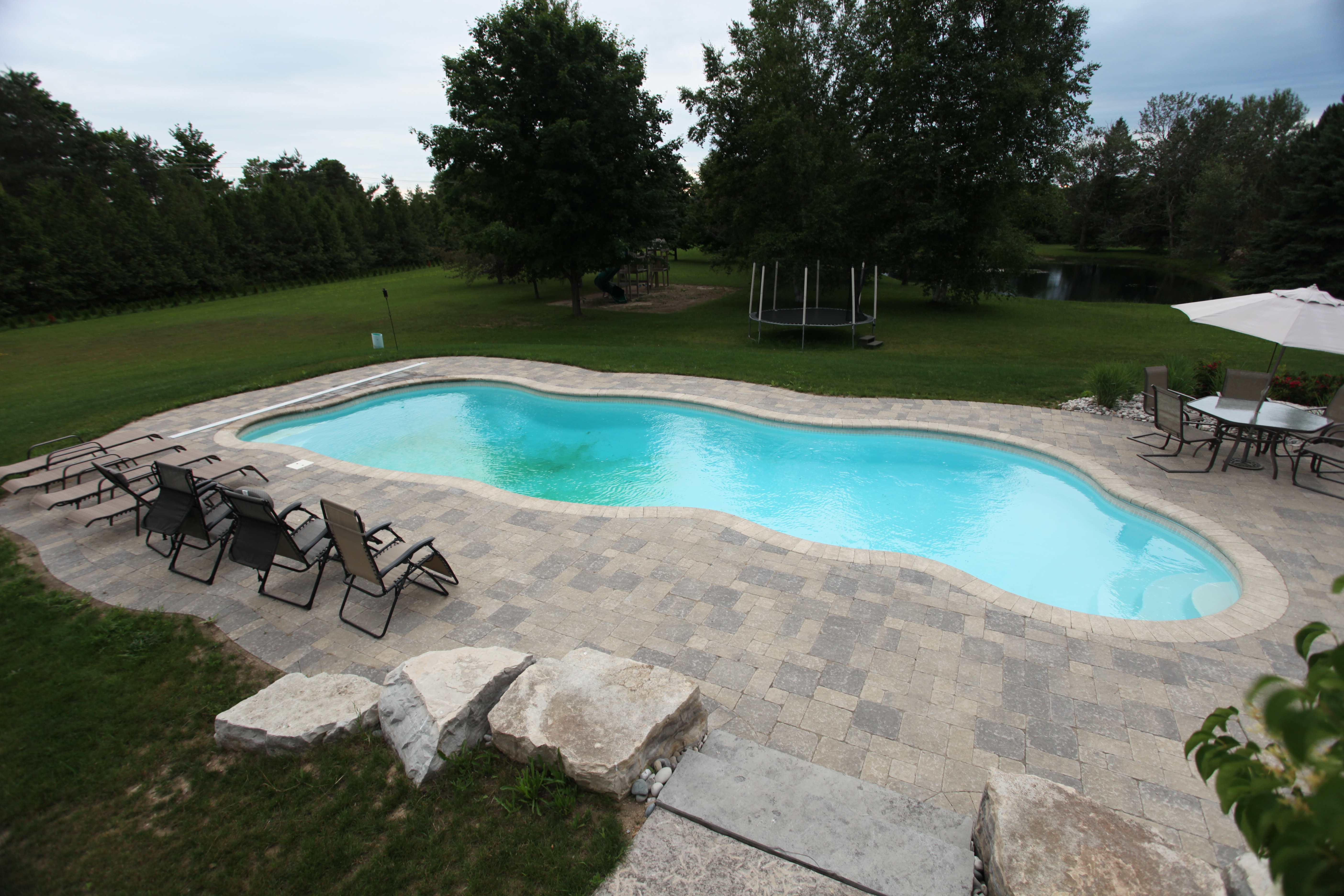 A serene inground pool in a modern backyard setting, perfect for a relaxing summer afternoon. The pool’s sleek design complements the surrounding landscape, creating a tranquil oasis in the desert.