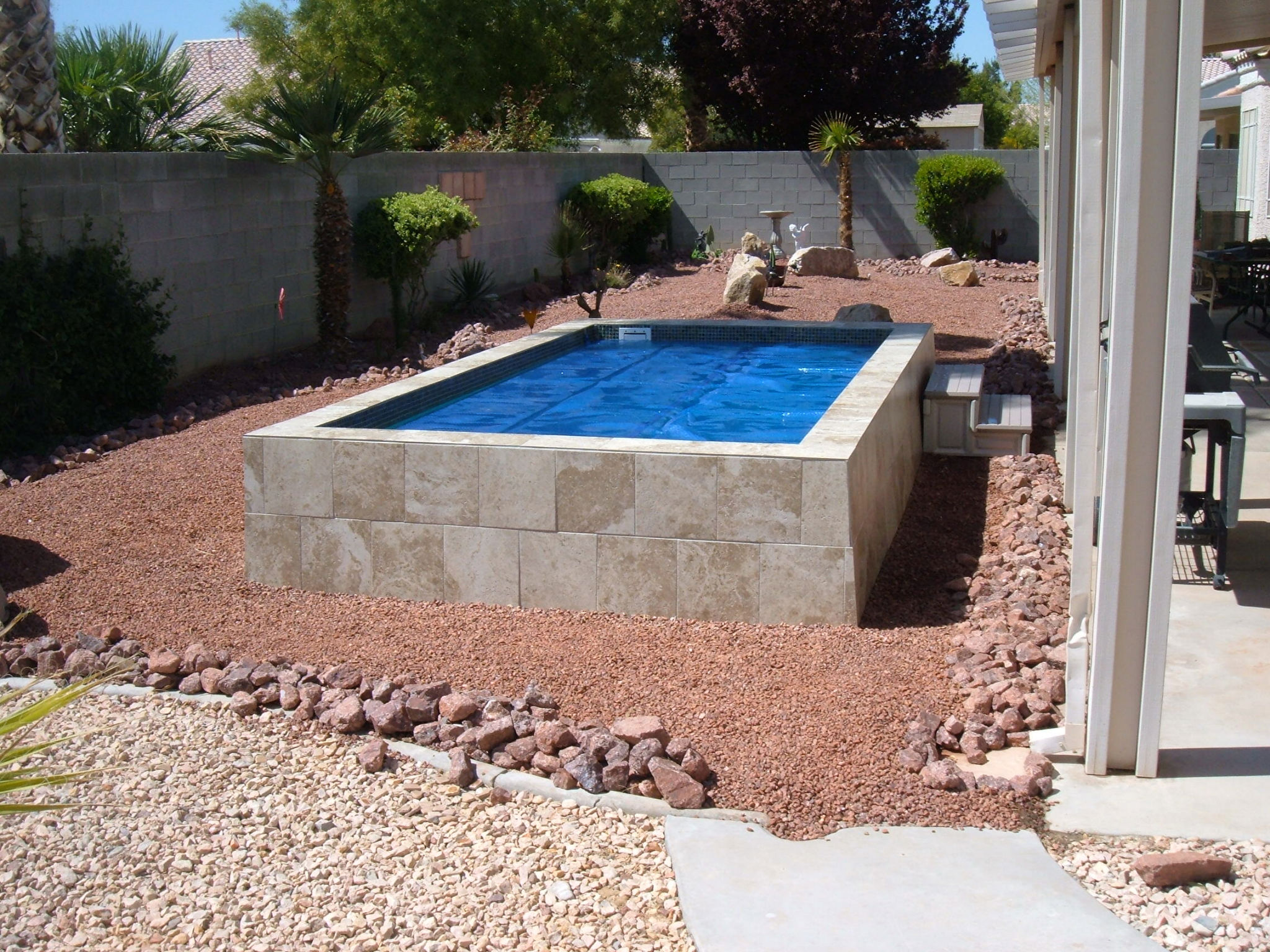 Experience tranquility in this fiberglass pool-centered backyard oasis, featuring a blend of natural elements and elegant design.