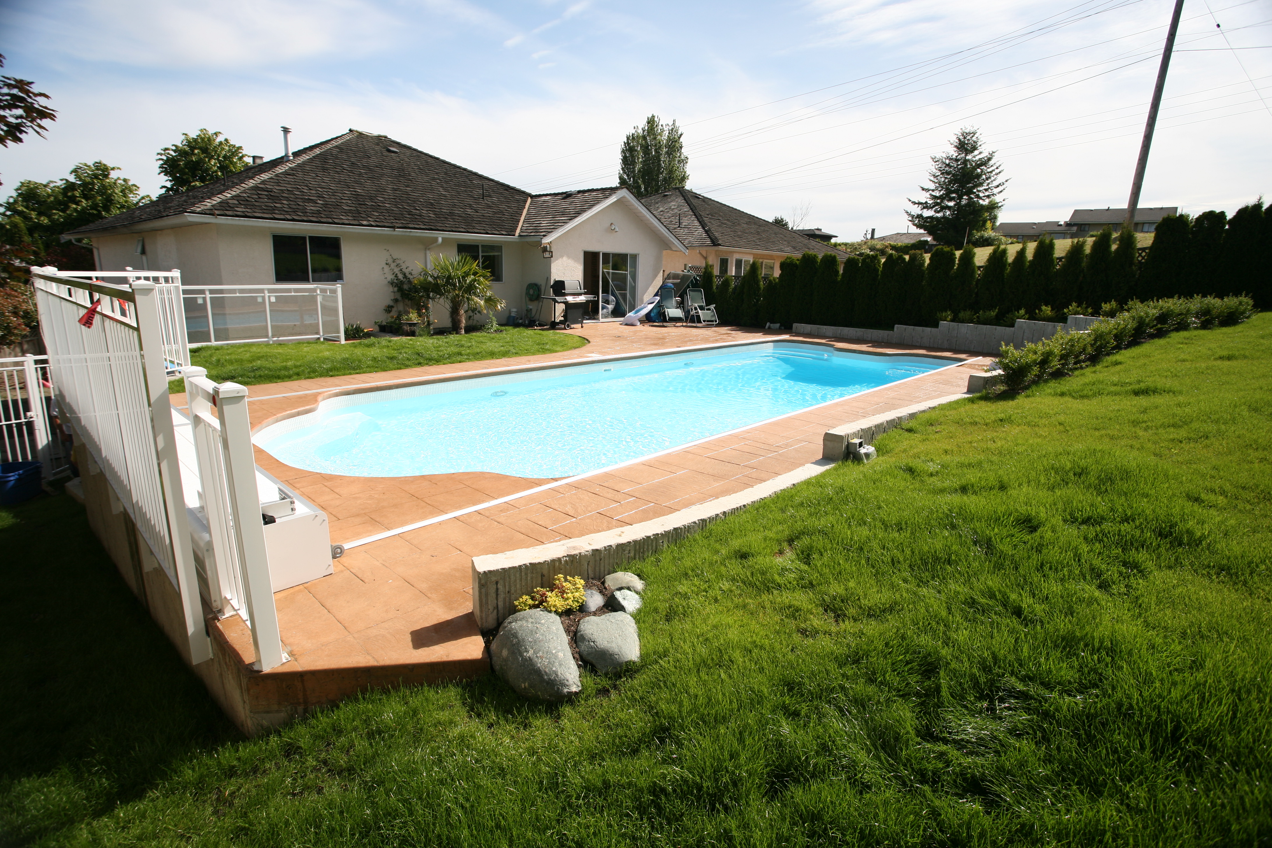Experience tranquility with this new fiberglass inground pool set amidst lush greenery and a serene backyard atmosphere.