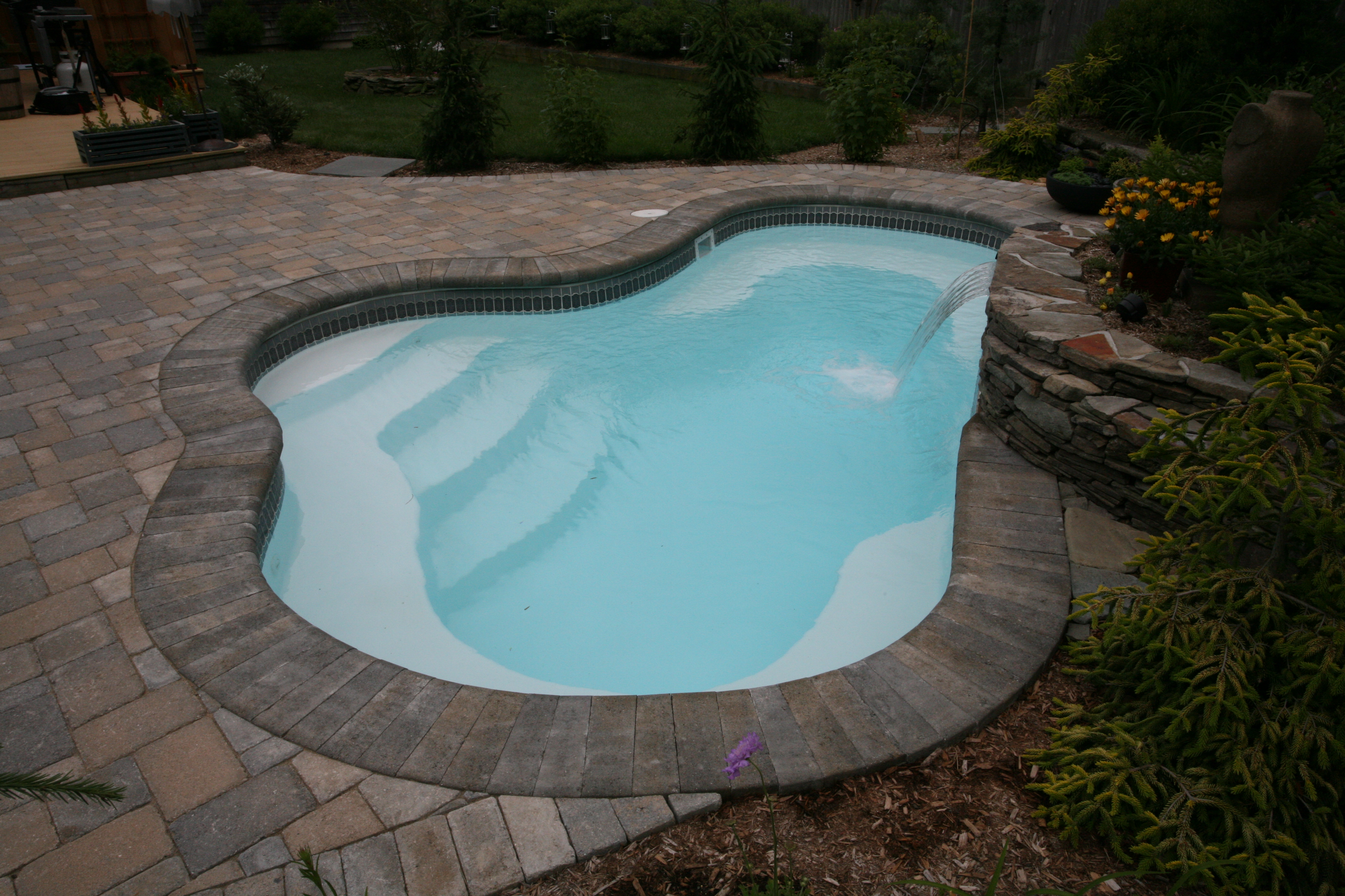 A serene inground pool in a Southwest backyard, perfect for hot summer days. The modern design blends seamlessly into the desert landscape, creating a relaxing oasis.