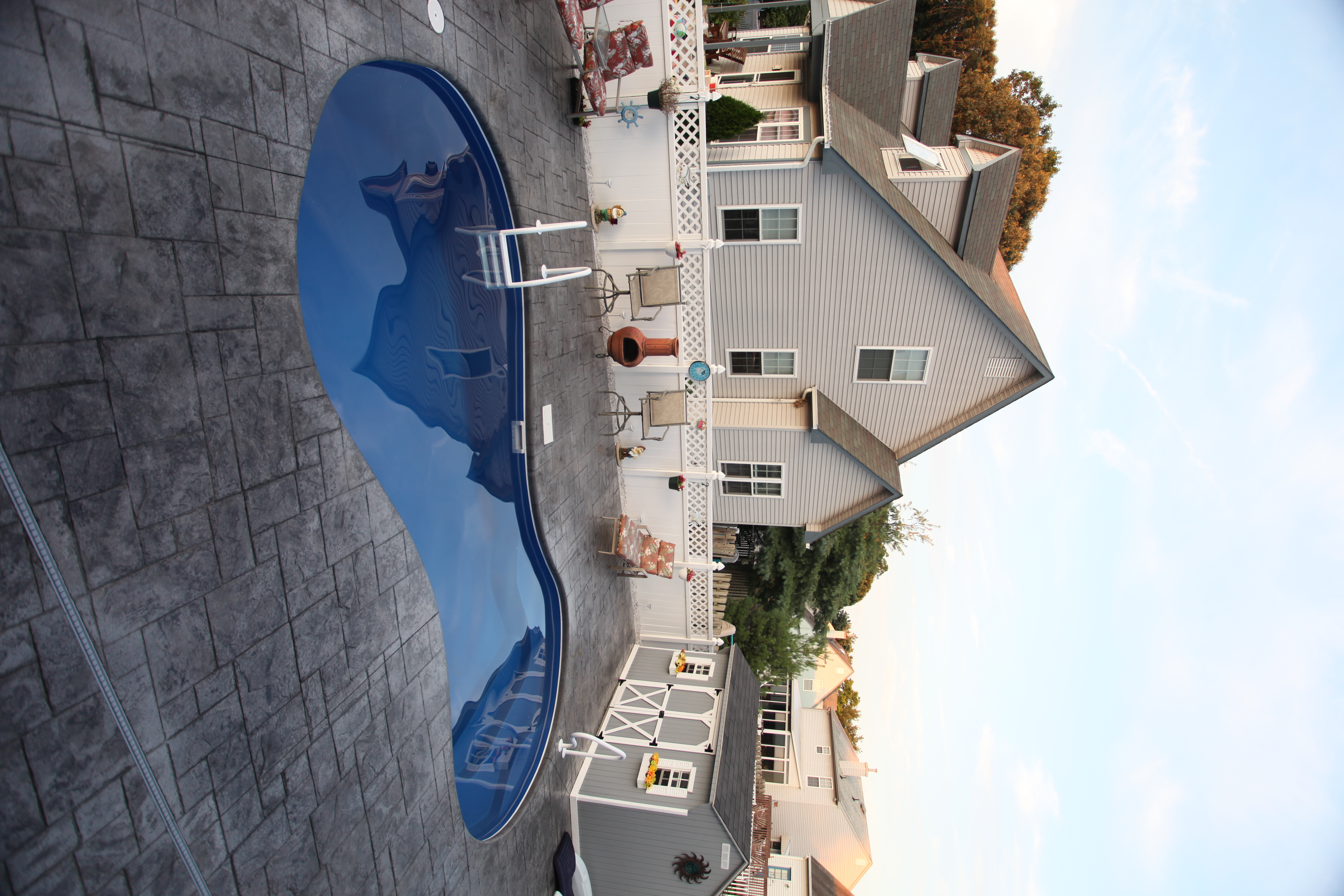 Experience serene leisure with this fiberglass kidney bean-shaped pool, perfectly complementing the coastal aesthetic of your backyard.