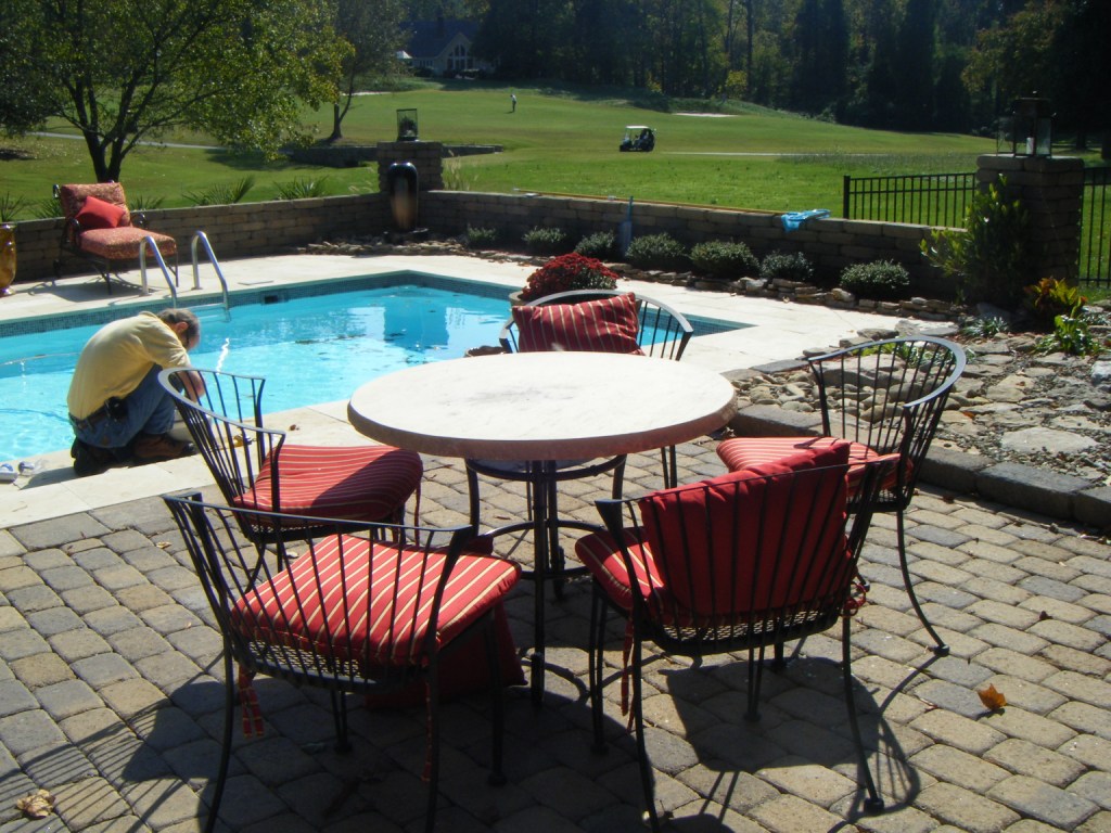 Enjoy a sparkling blue San Juan fiberglass pool set in a sun-kissed resort patio, perfect for relaxing summer days.