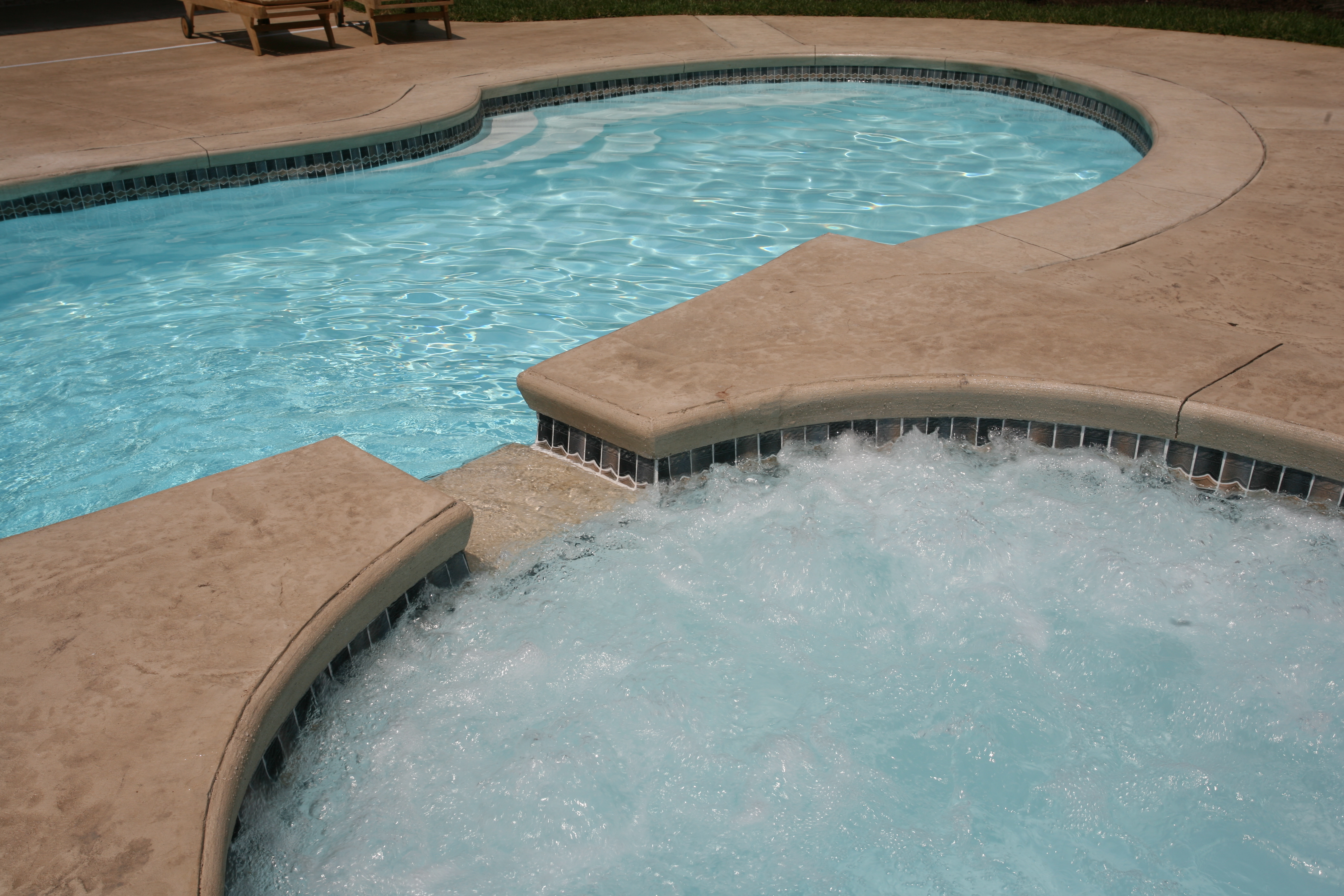 Experience a sun-kissed backyard oasis with San Juan’s premium fiberglass pool, seamlessly integrated with lush landscaping and a relaxing hot tub.