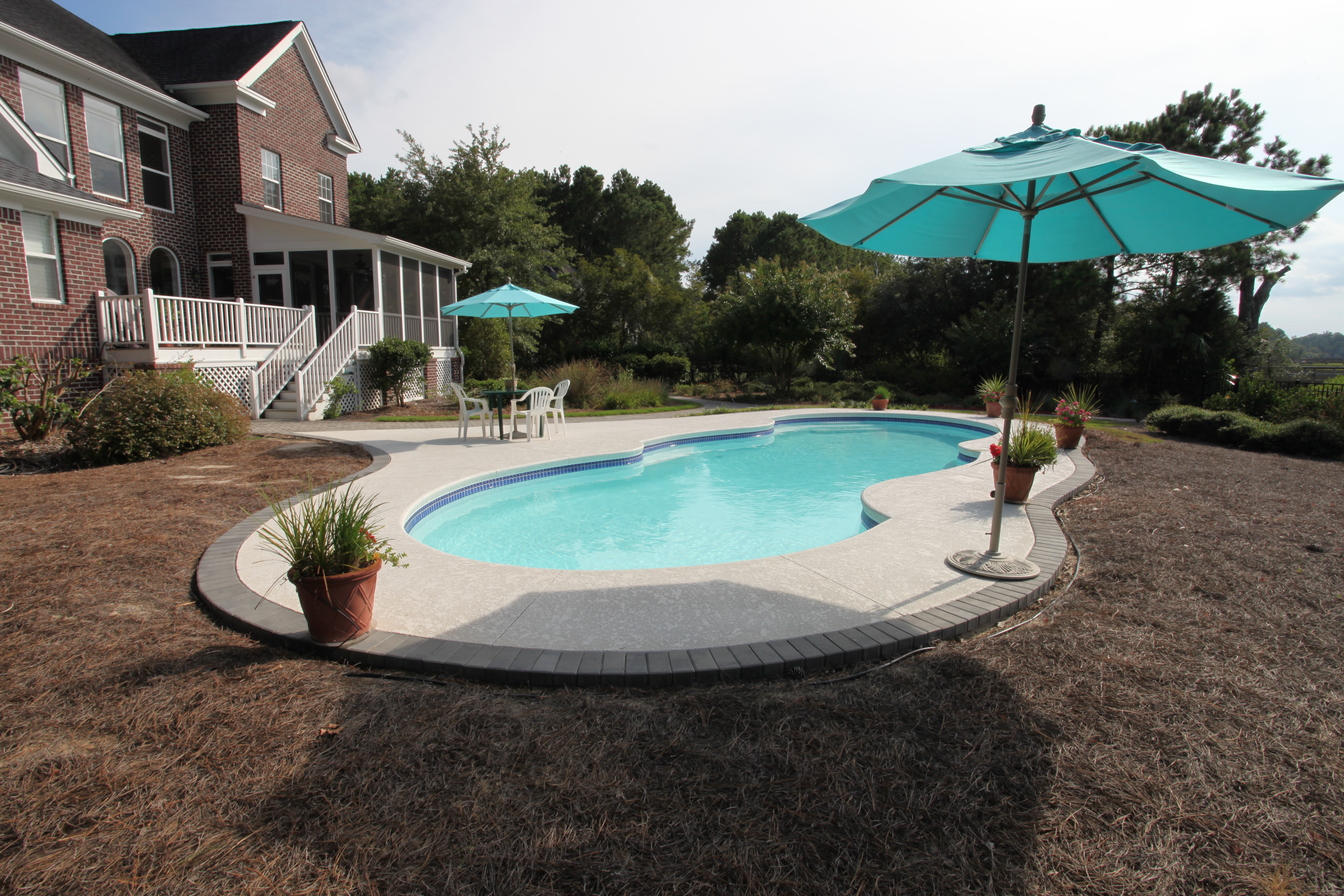 Experience tranquil luxury with this pristine kidney-shaped fiberglass pool, set in a sun-kissed backyard oasis.
