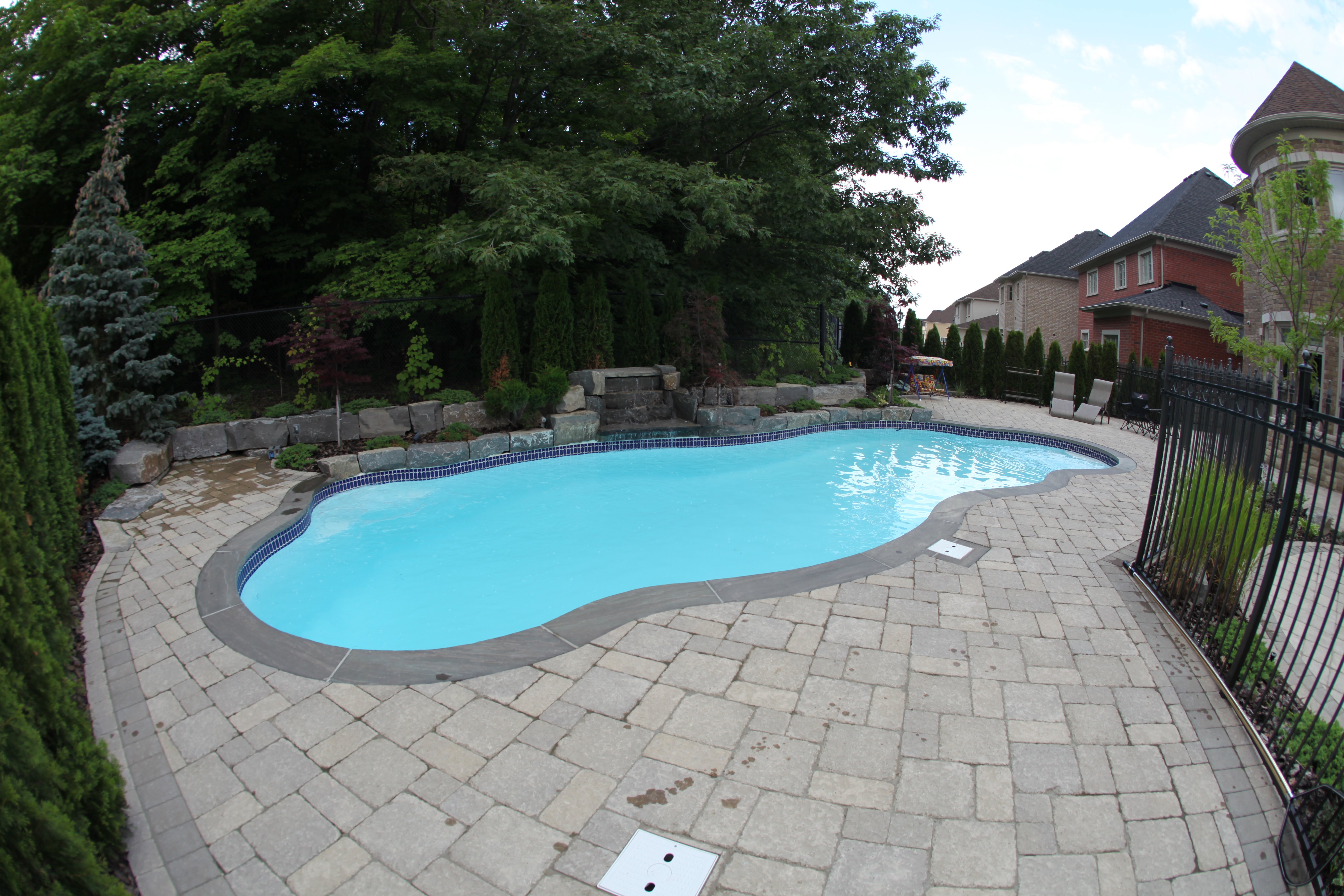 Discover serenity with this unique kidney bean-shaped San Juan fiberglass pool, perfectly blended into a meticulously maintained backyard oasis.
